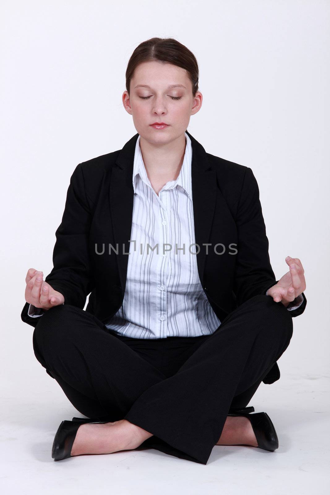 Young businesswoman meditating to relieve stress