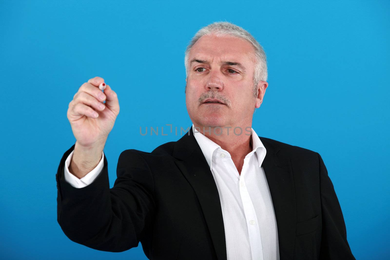 Businessman gesturing with pen by phovoir