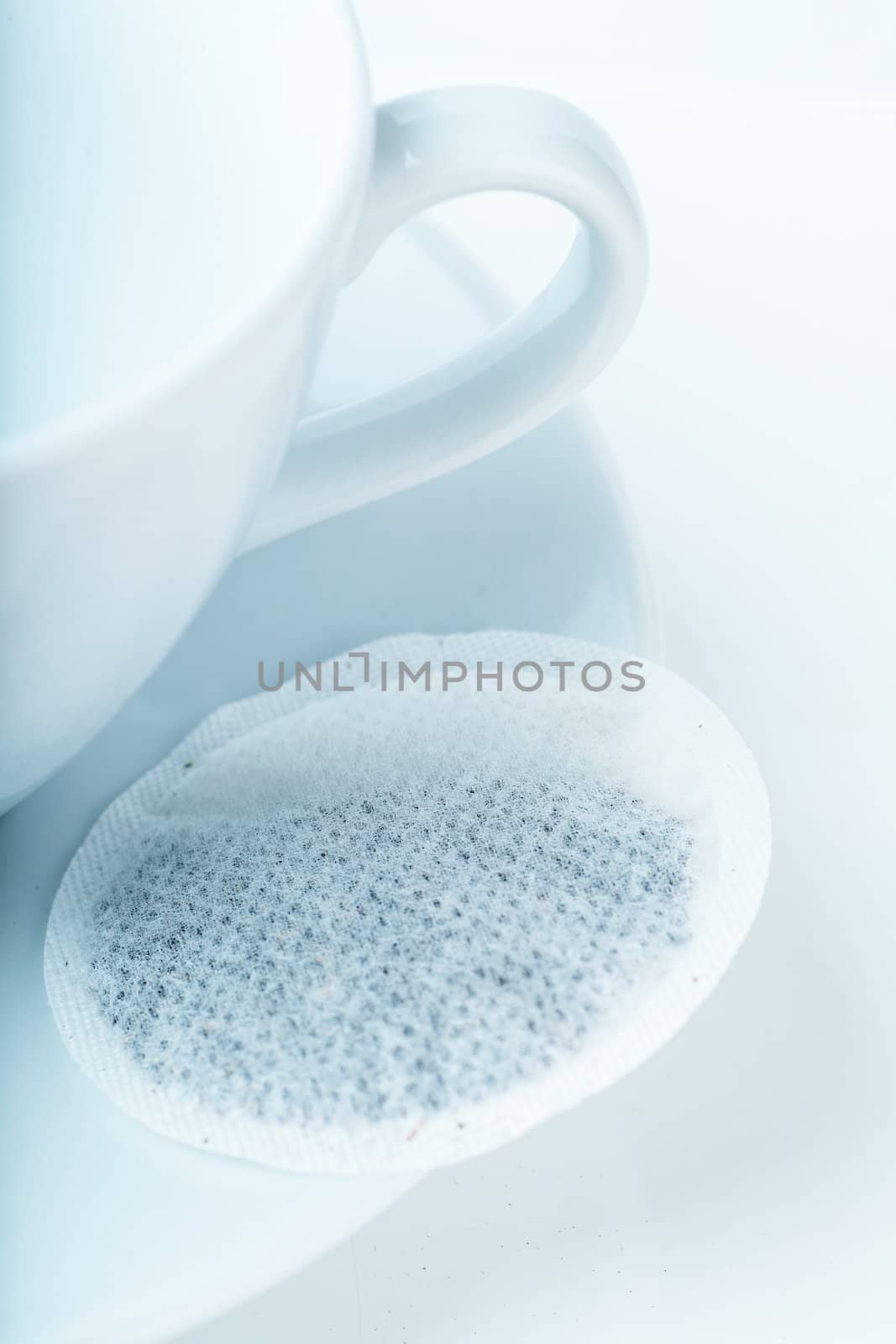 Closeup view of empty cup and teabag on a plate
