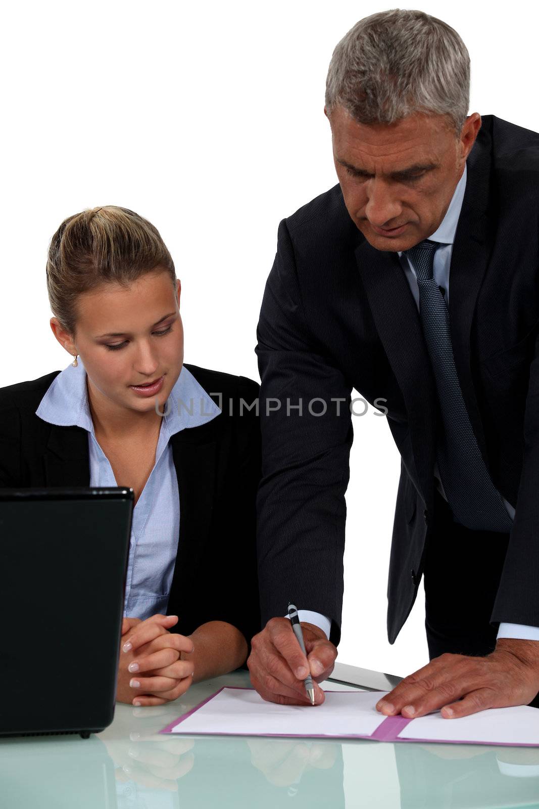 Boss looking through document with employee by phovoir