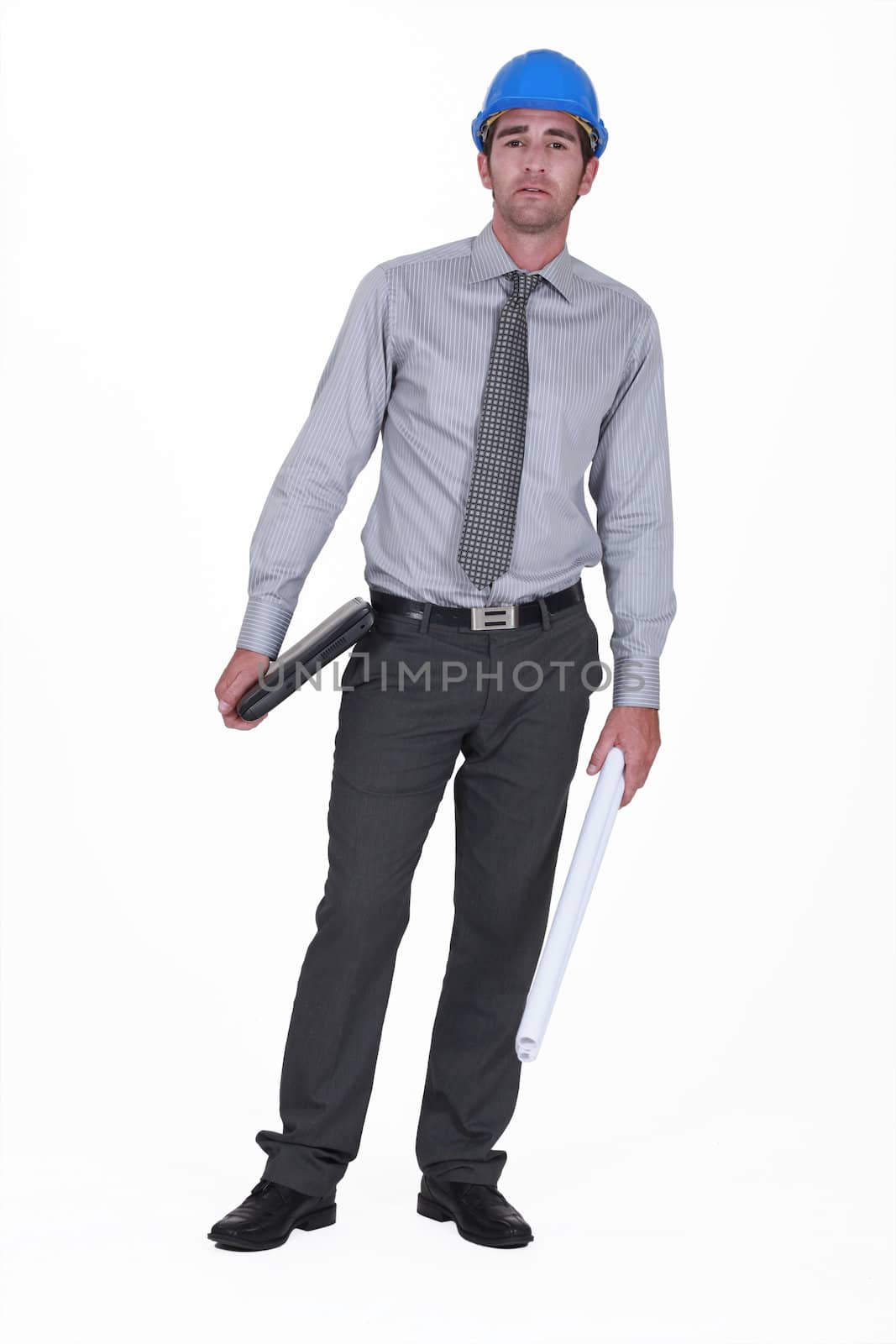 businessman wearing a helmet and holding a laptop by phovoir