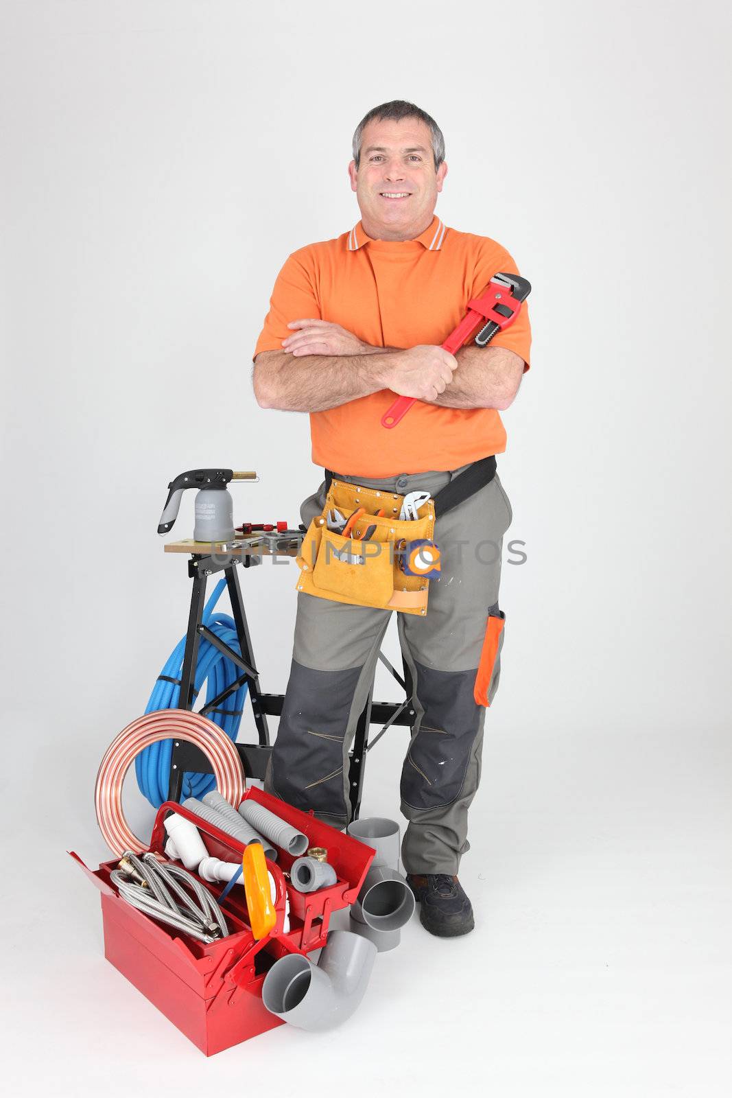 Studio shot of a plumber with tools of the trade by phovoir