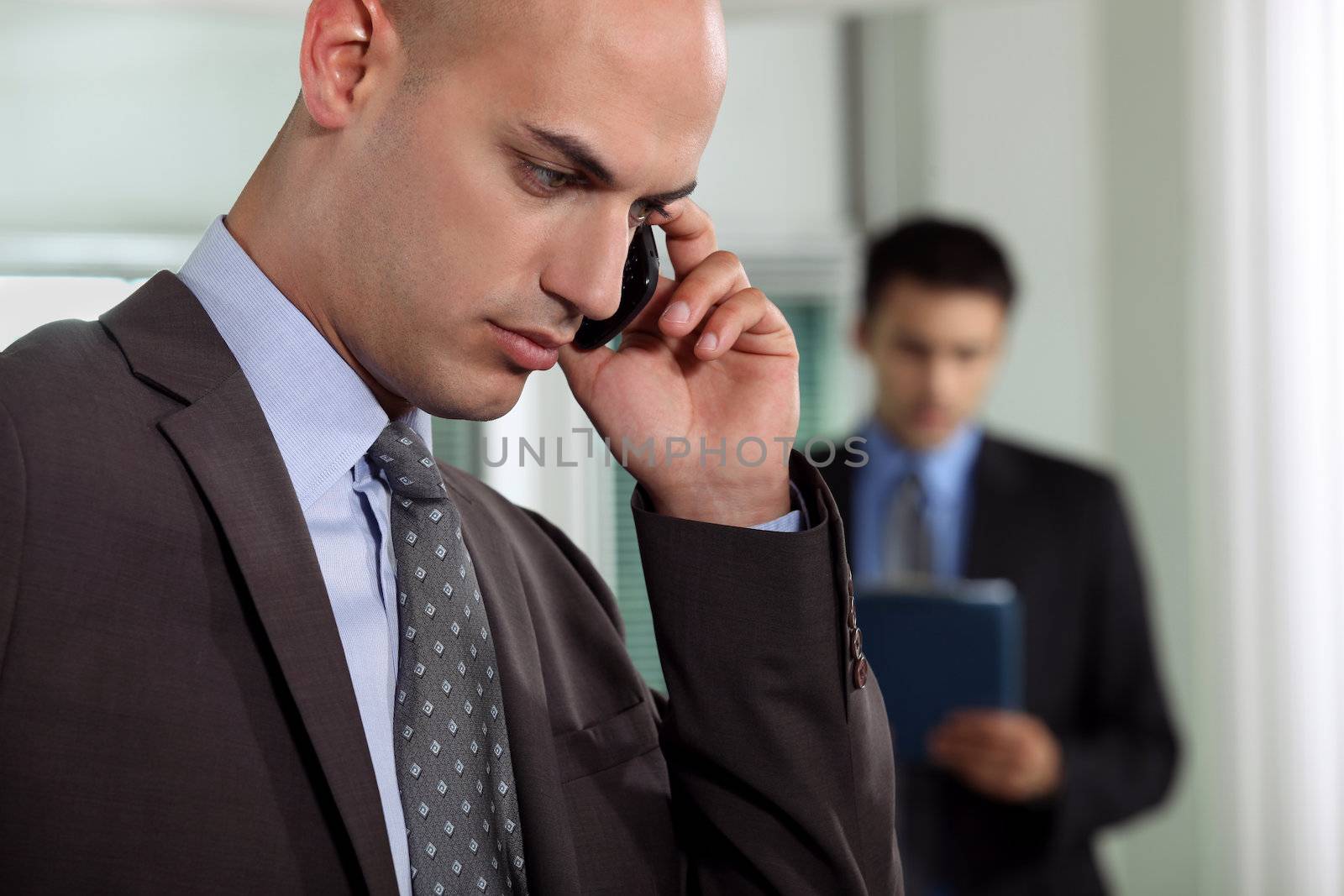 Businessmen negotiating over the phone by phovoir