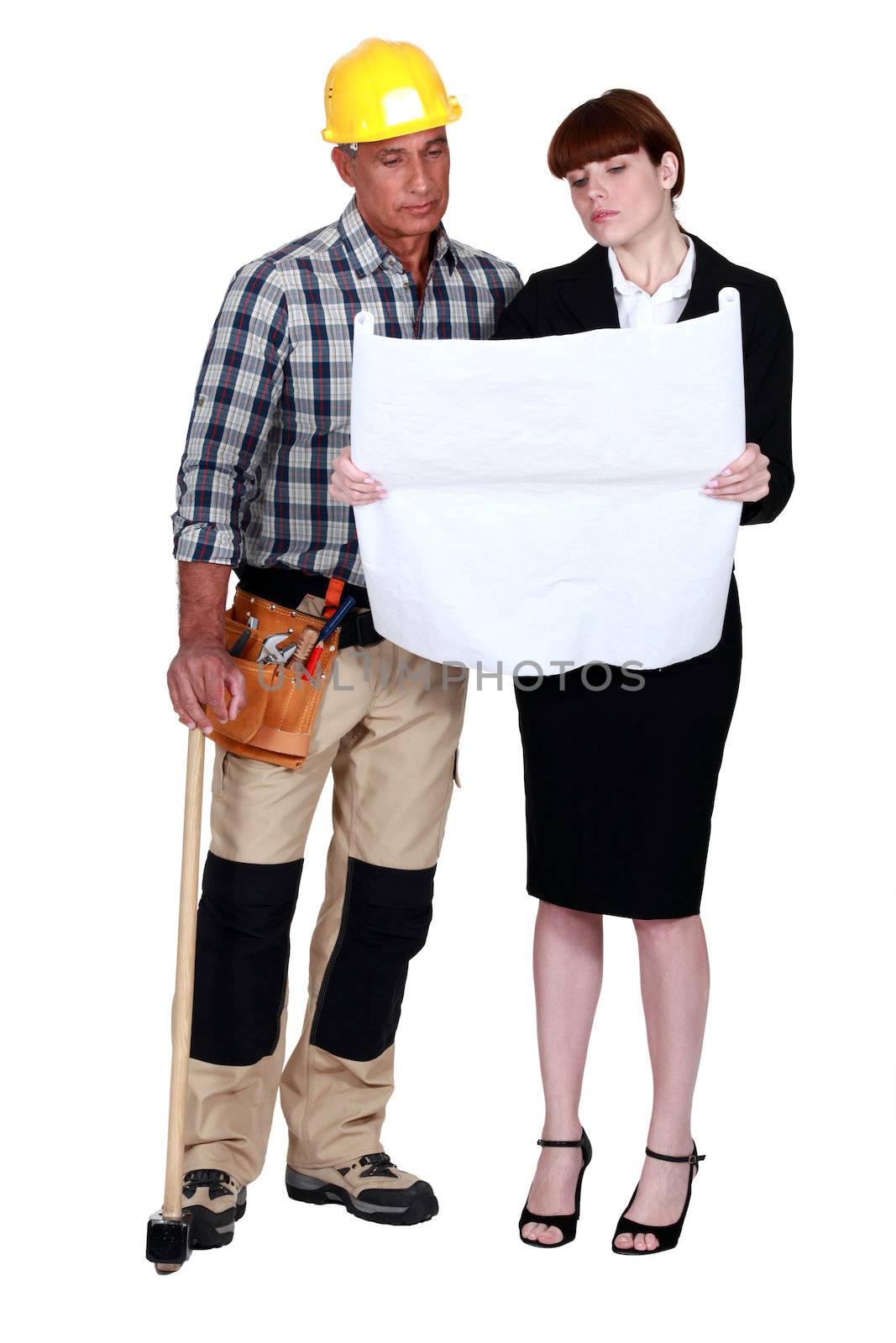 craftsman and businesswoman looking at a blueprint by phovoir