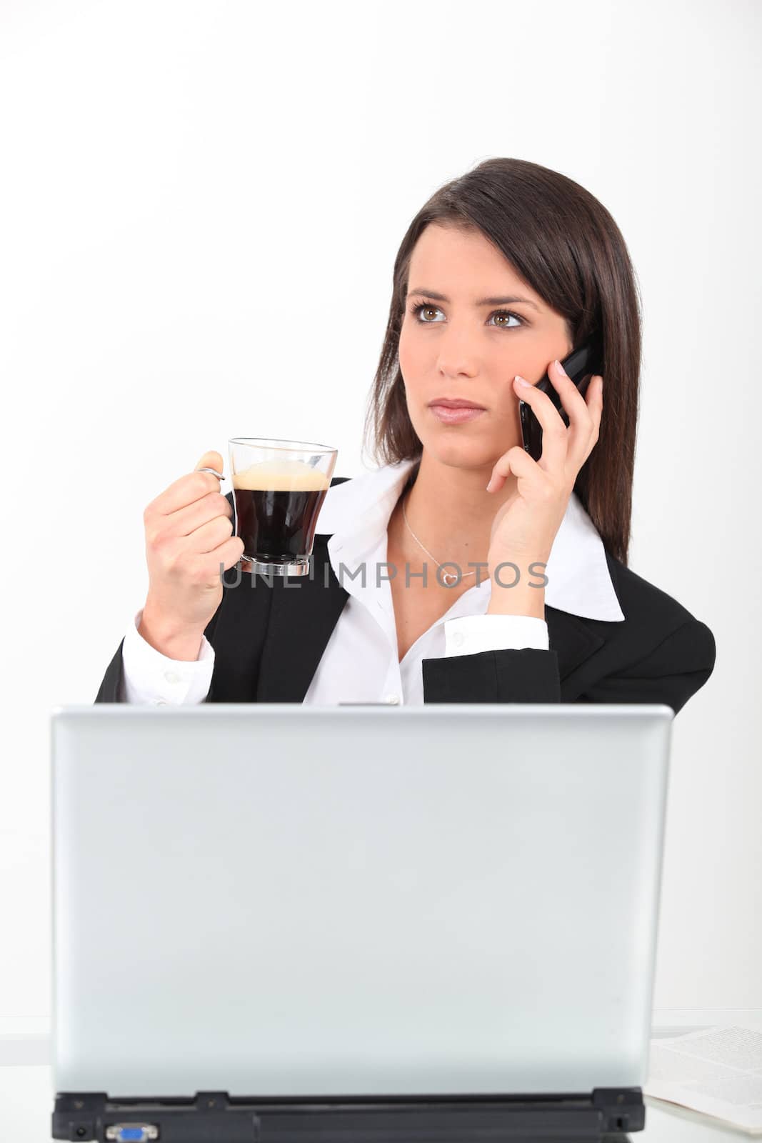 Woman at laptop with coffee by phovoir