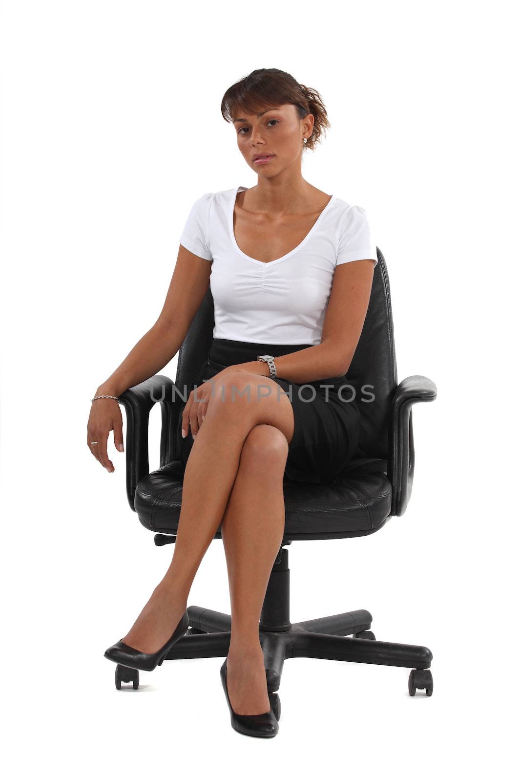 Businesswoman sat in office chair by phovoir