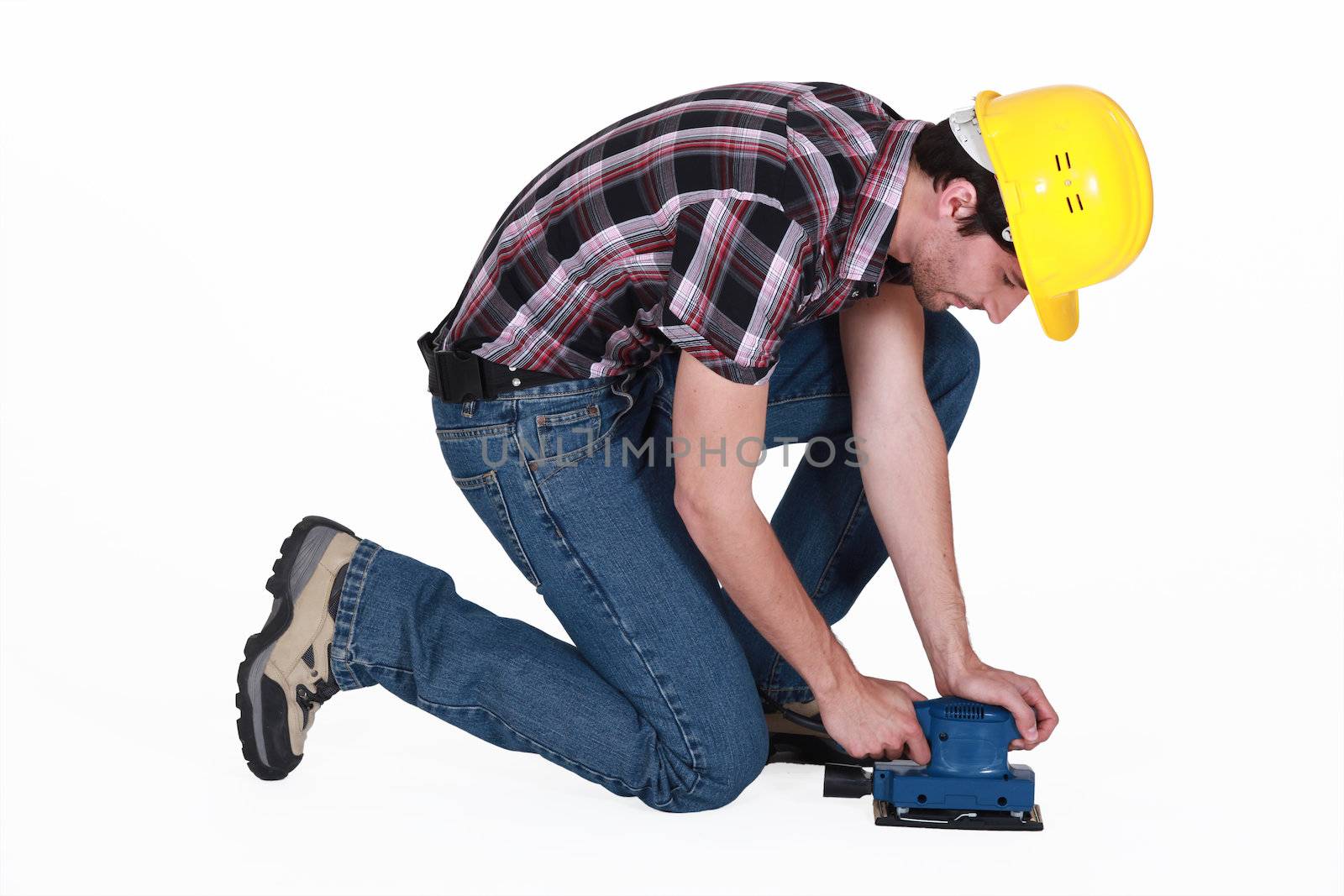 Workman using an electric sander by phovoir