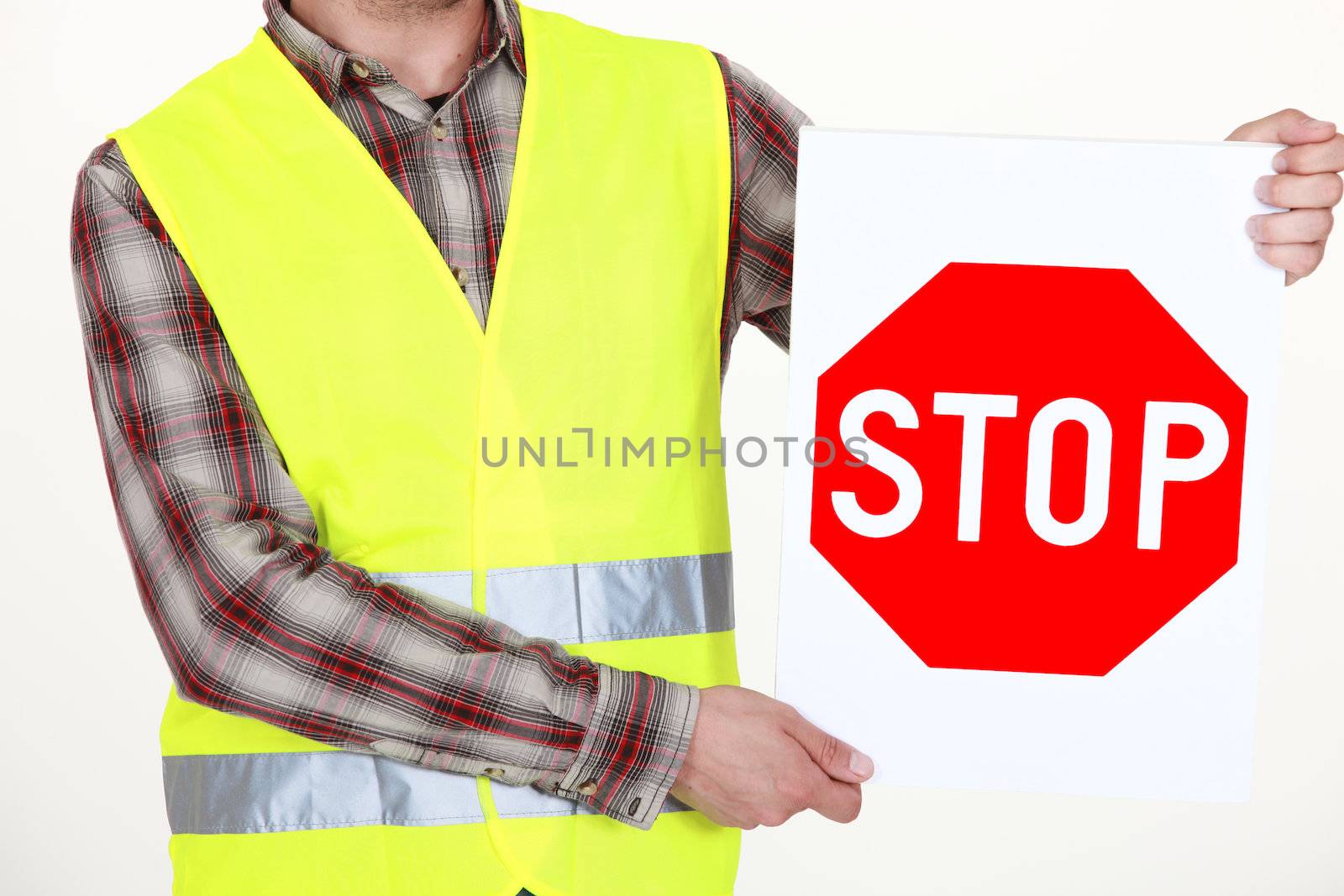 A cropped picture of a road worker holding a stop sign. by phovoir