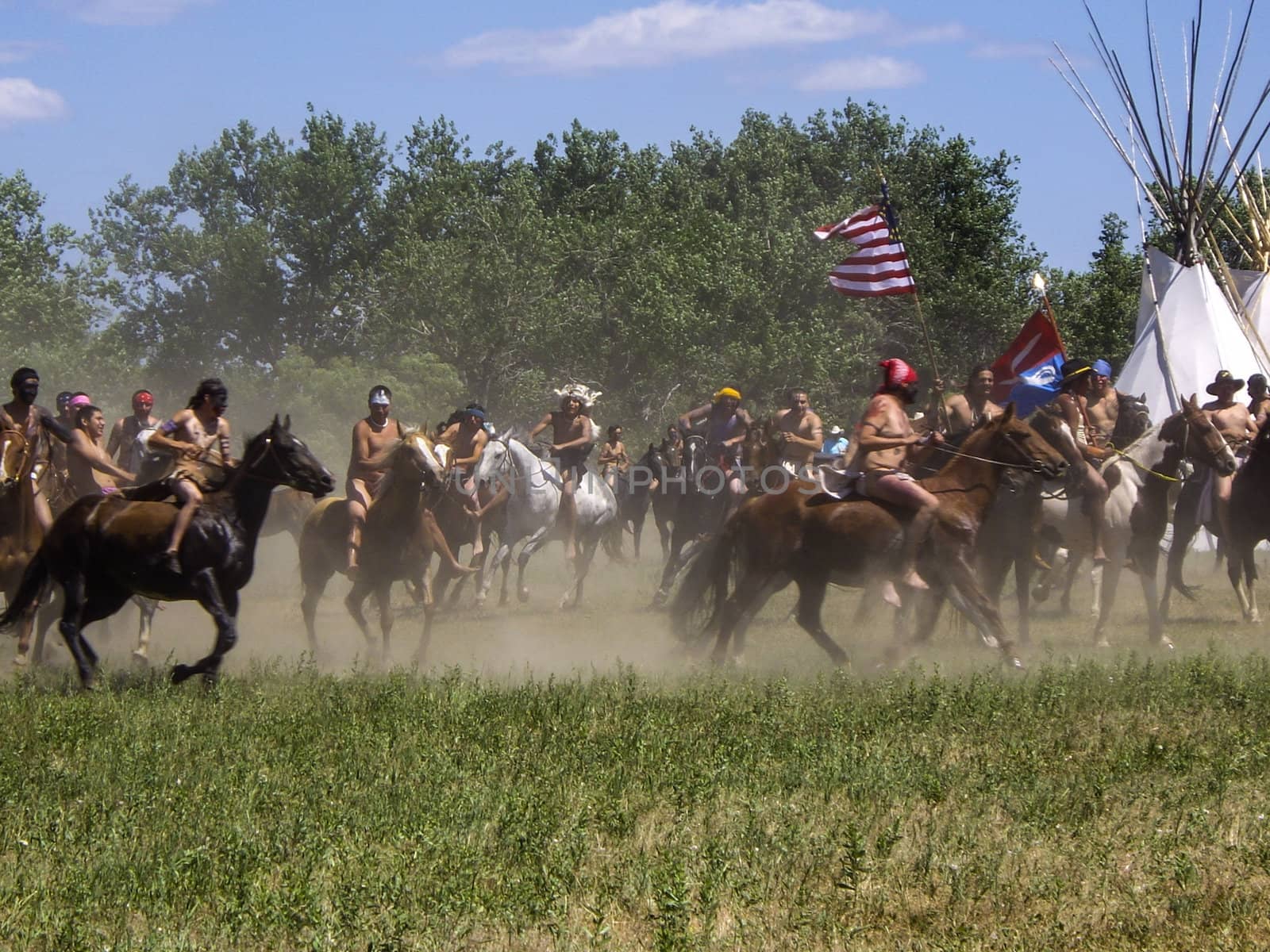 Indians on horseback kick up dust in reenactment of Battle of Bighorn