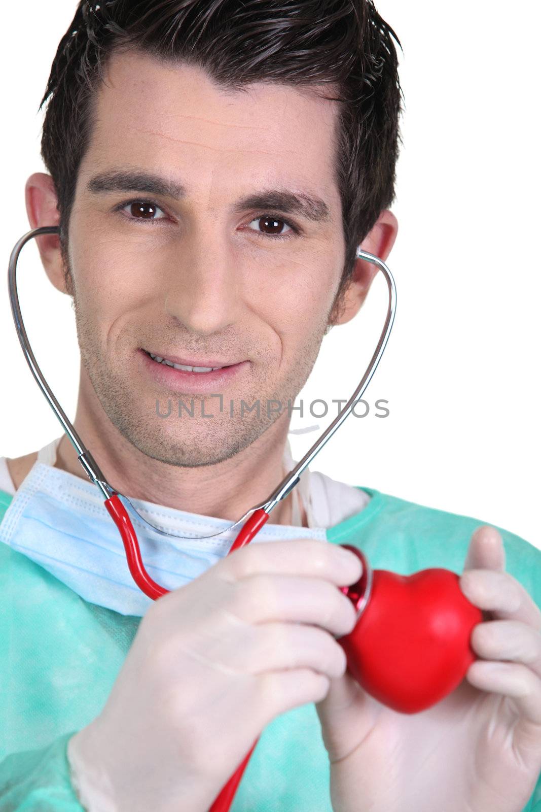 Young doctor listening to a model heart through a stethoscope