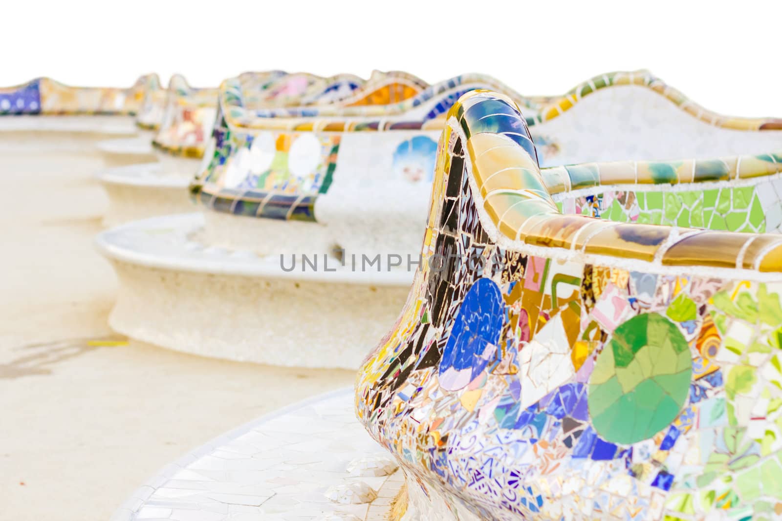 Closeup of colorful ceramic mosaic in a bench of park Guell, isolated on white background. The bench was designed by Antonio Gaudi, in Barcelona, Spain