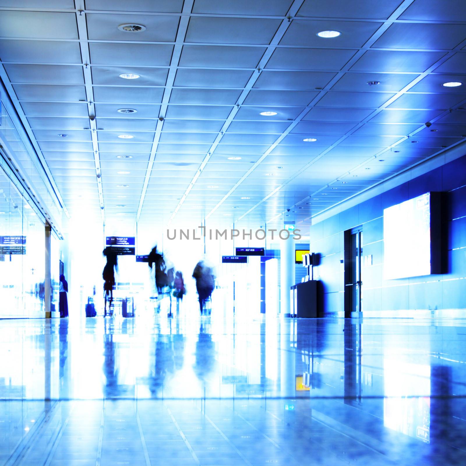 Passengers walking in contemporary hallway of airport