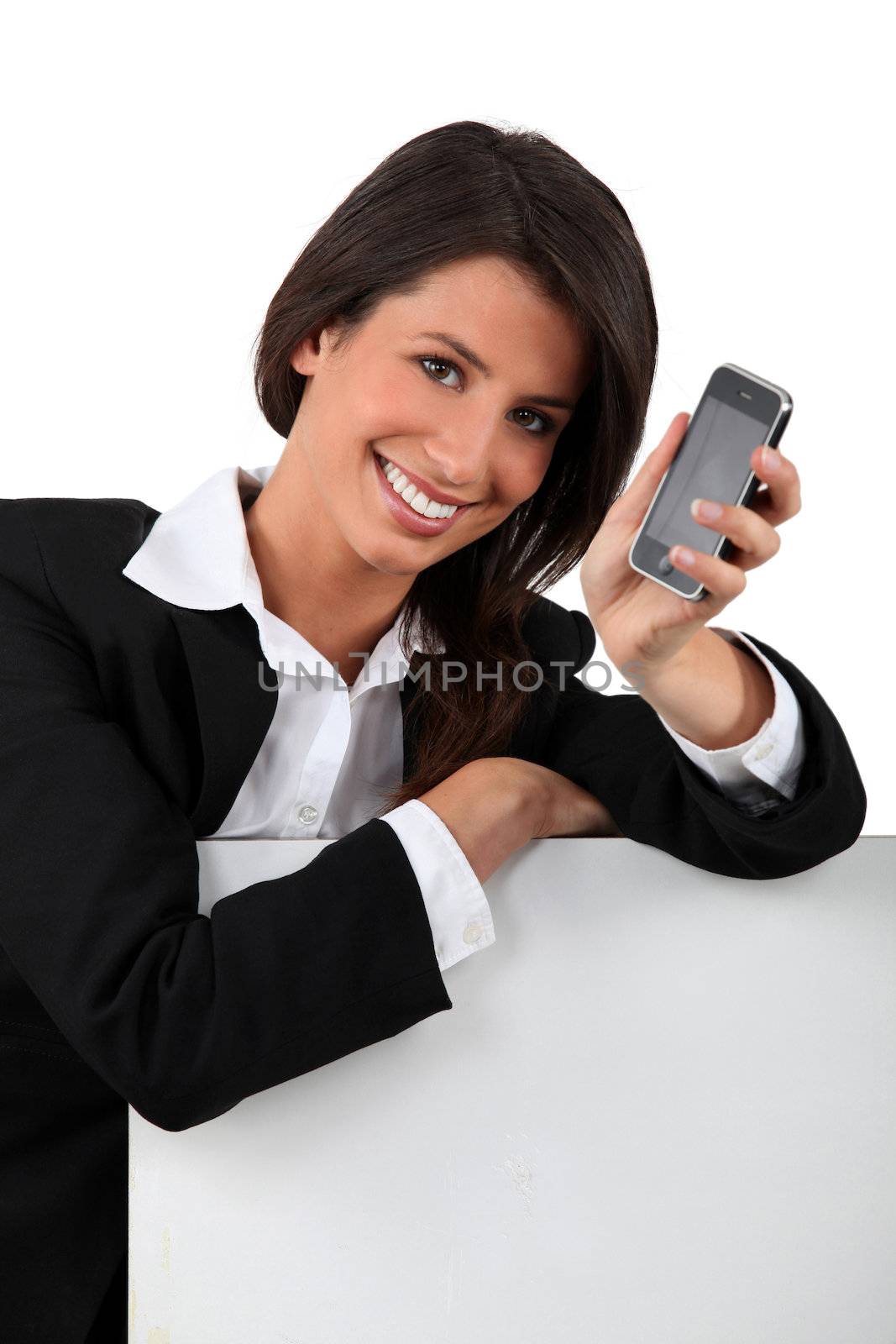 Young woman holding mobile telephone by phovoir