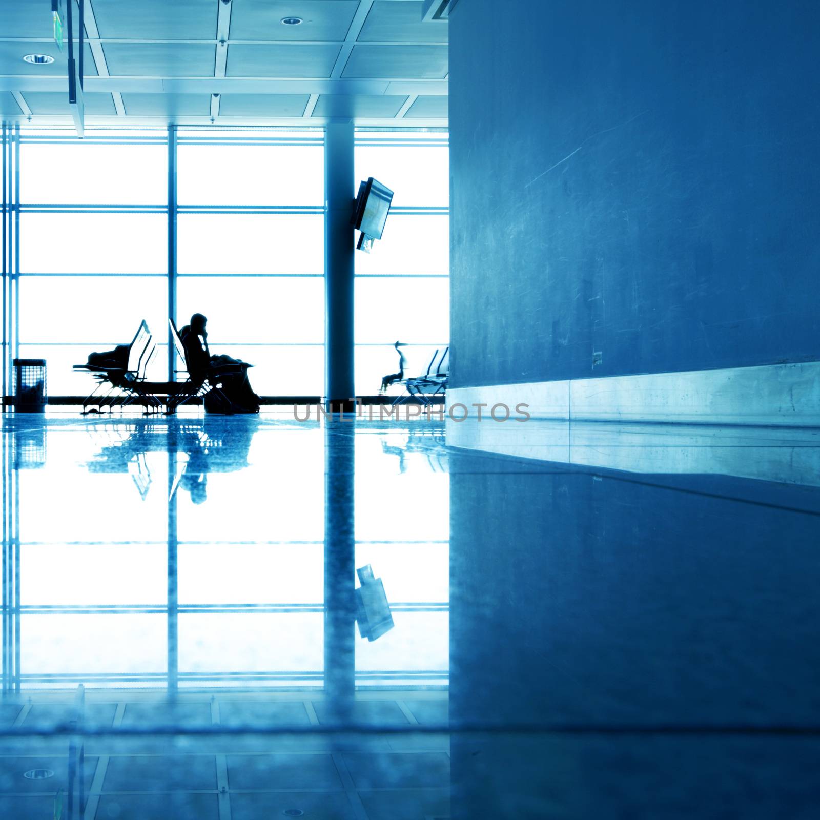 Passengers in contemporary hallway of airport waiting for departure