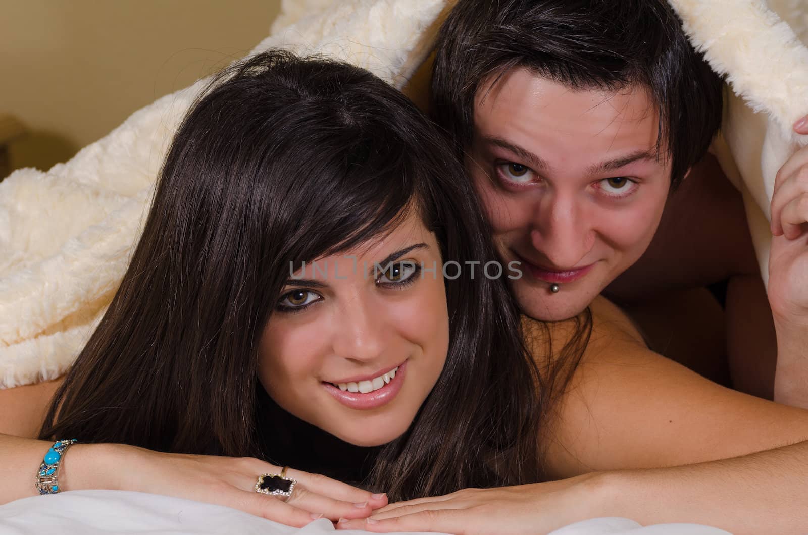 Mixed Caucasian and Latina couple  under a woolen blanket