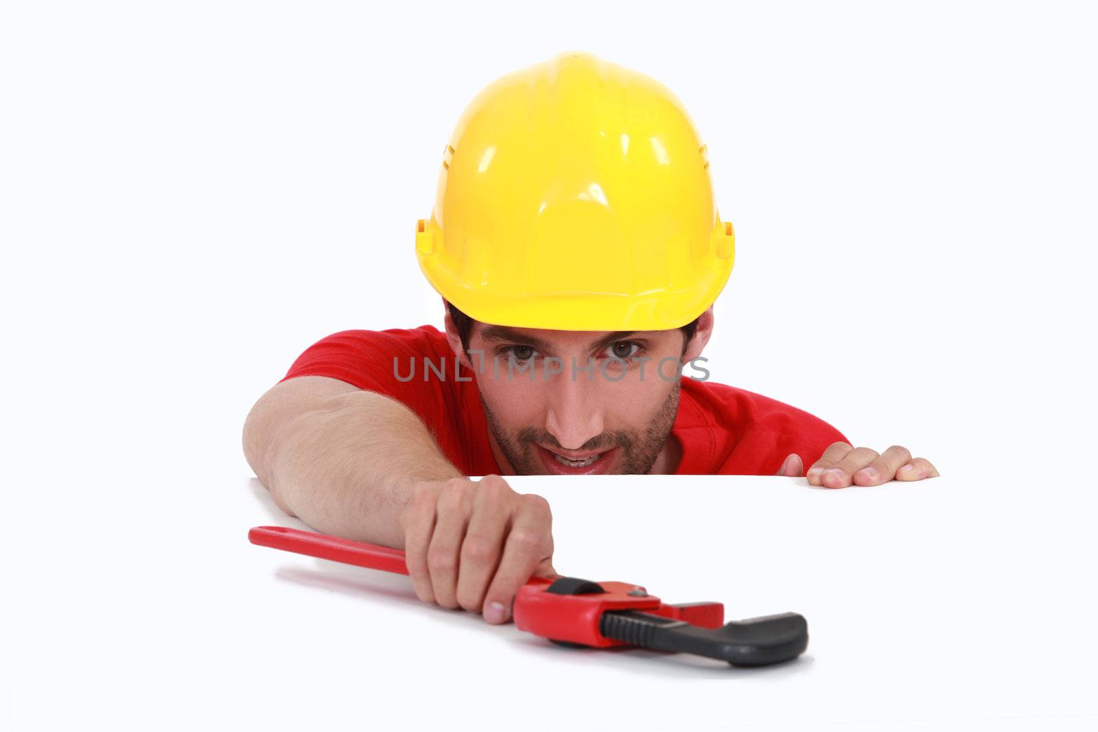 Manual worker resting wrench on white surface