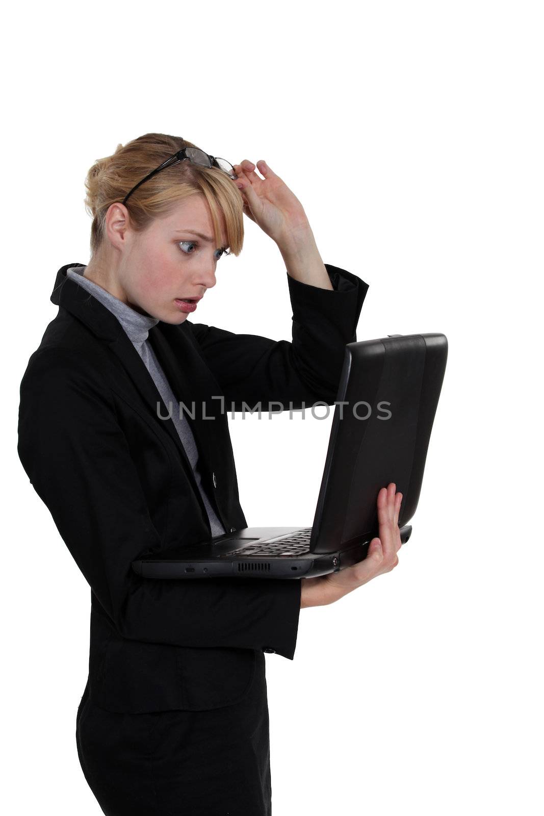 Shocked woman holding laptop by phovoir