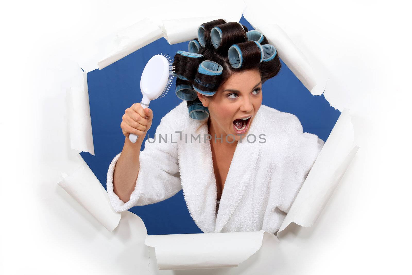 Angry woman with hair rollers and brush by phovoir
