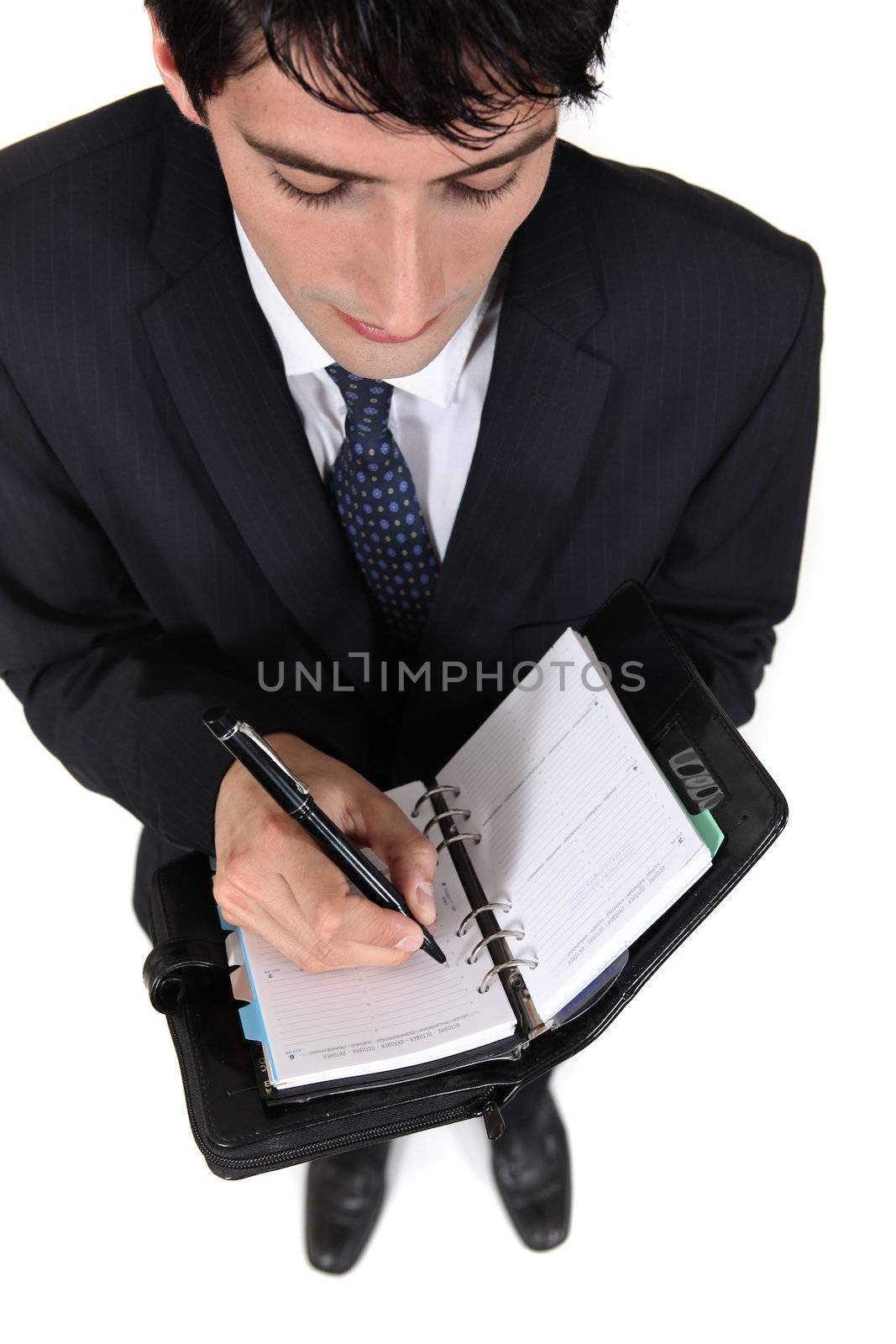 Businessman scheduling an appointment into his agenda by phovoir