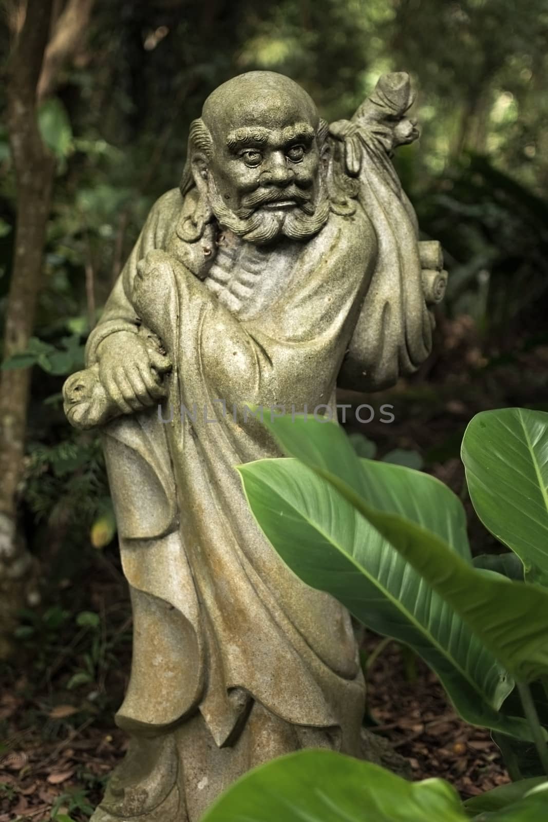 Old ruined Arhat Kanakbharadvaja statue in forest, Taiwan, Asia.