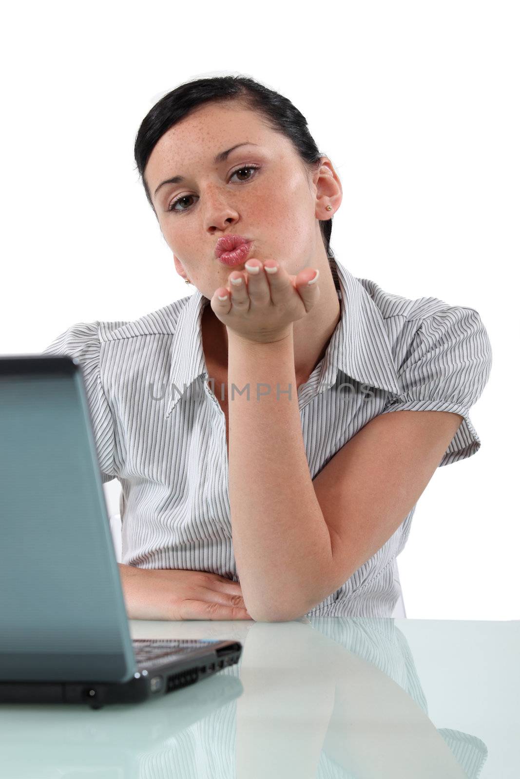 Woman at desk blowing kiss by phovoir