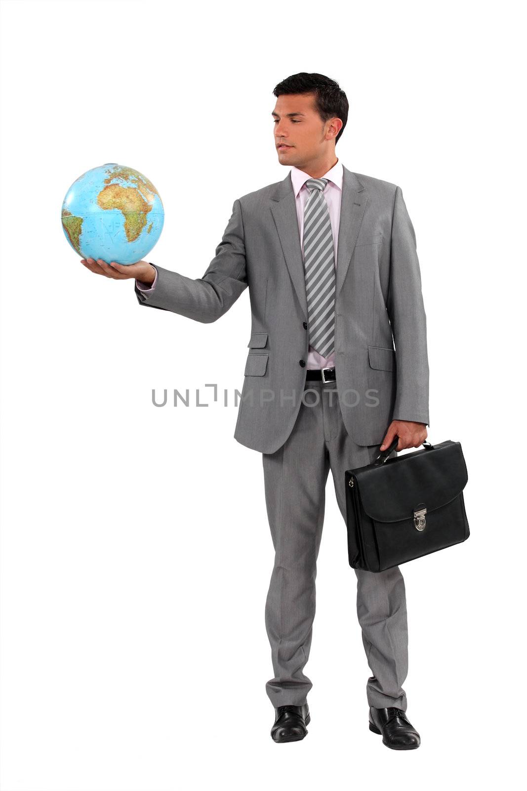 Businessman holding globe by phovoir
