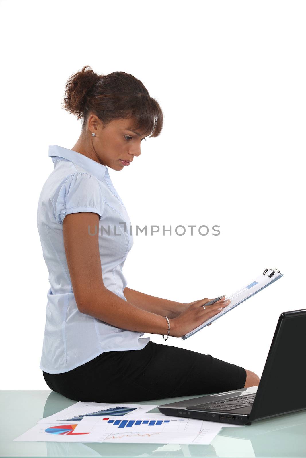 Woman sat with laptop and clip-board by phovoir