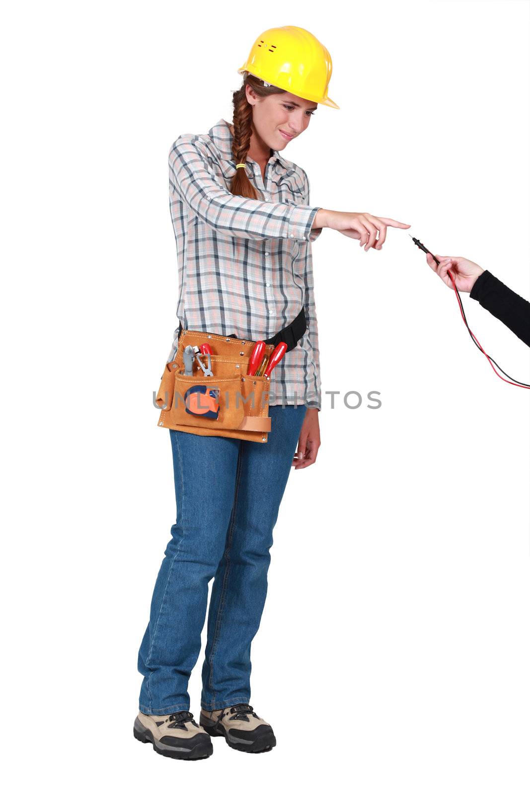 Female laborer touching an electrical wire by phovoir