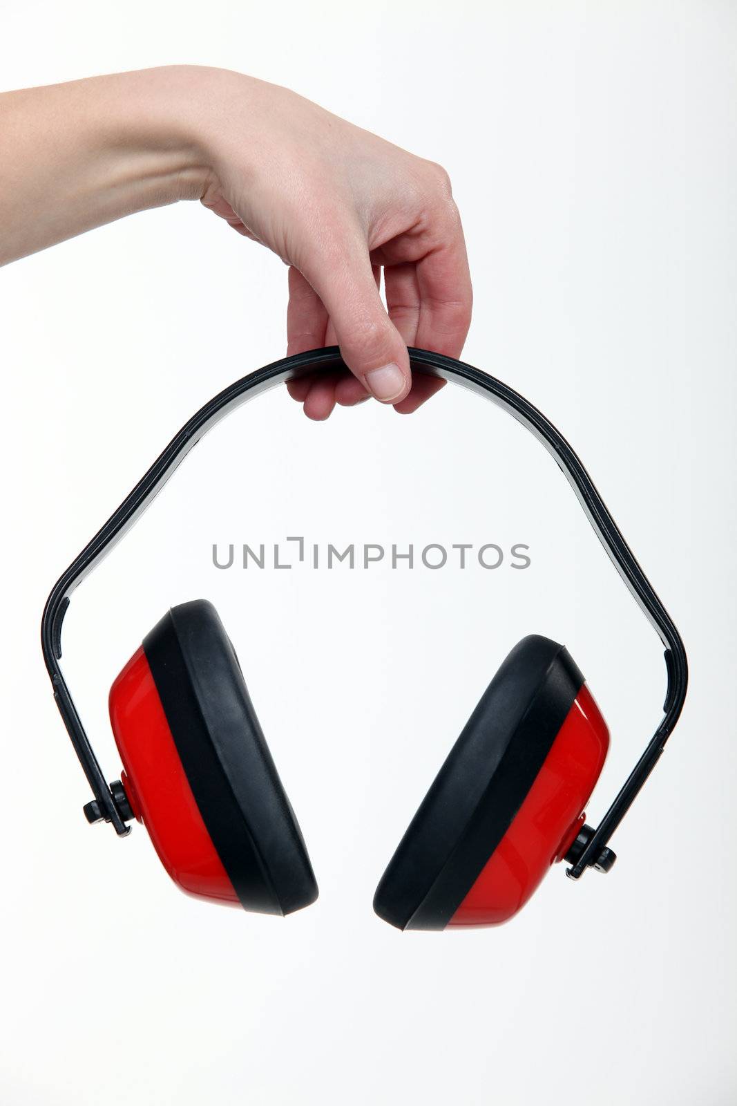 Hand holding a pair of ear defenders by phovoir