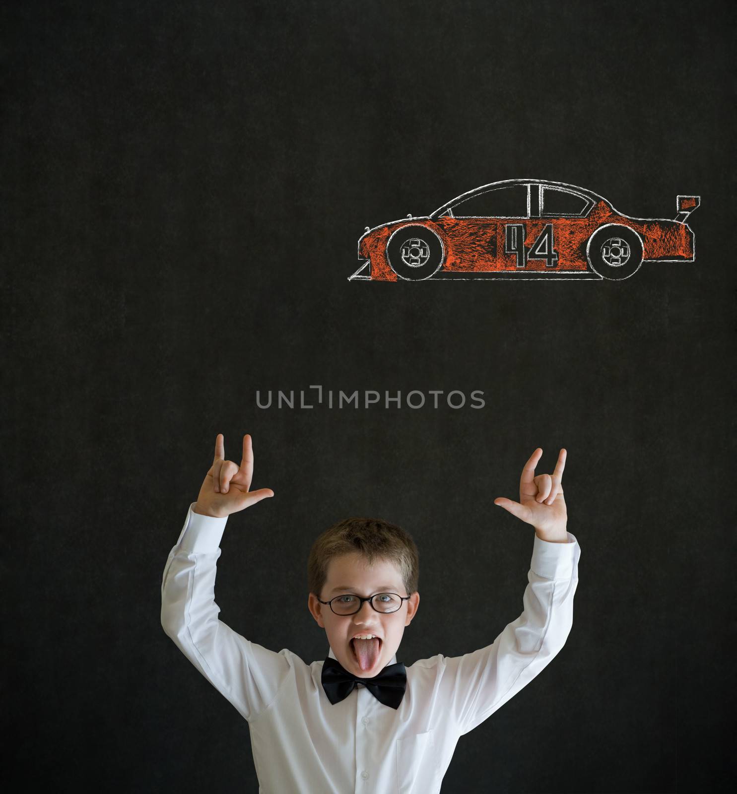 Knowledge rocks boy dressed up as business man with Nascar racing fan car on blackboard background