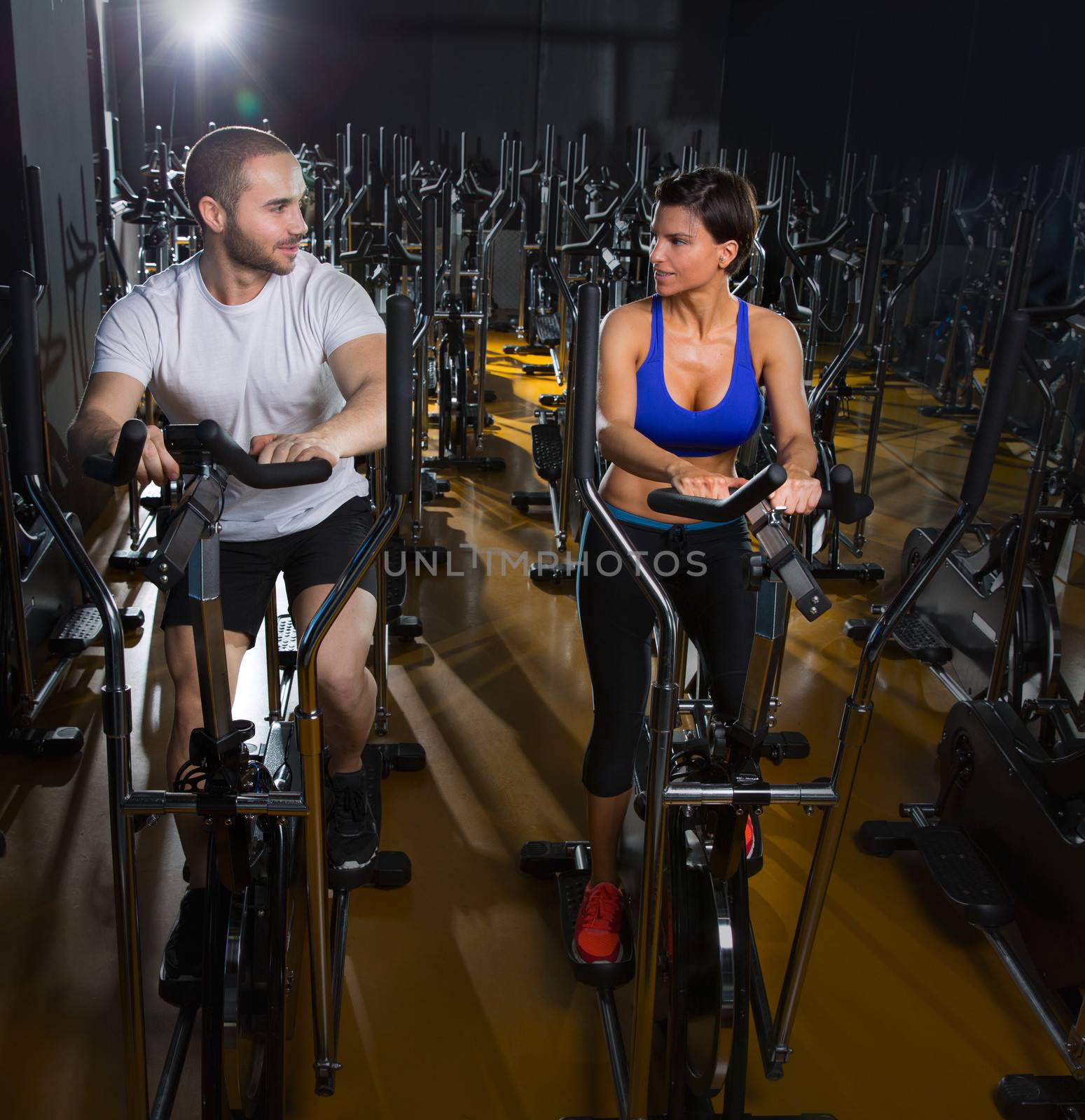 elliptical walker trainer man and woman at black gym training aerobics exercise