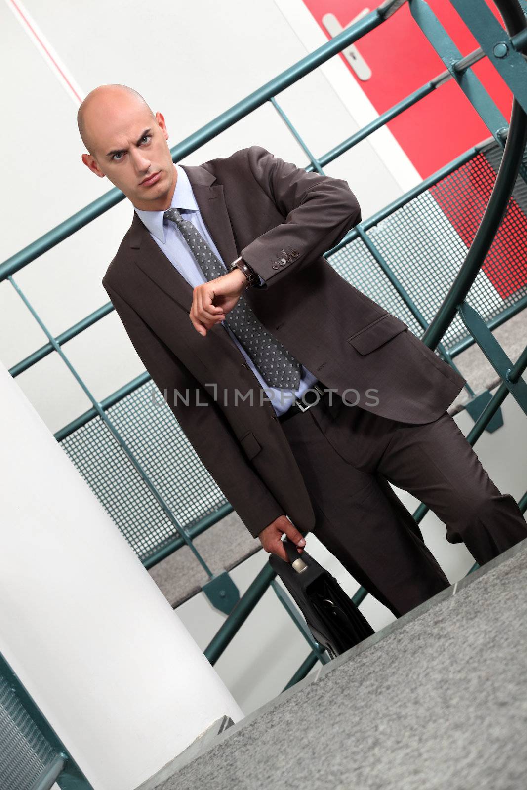A businessman climbing stairs to his appointment. by phovoir