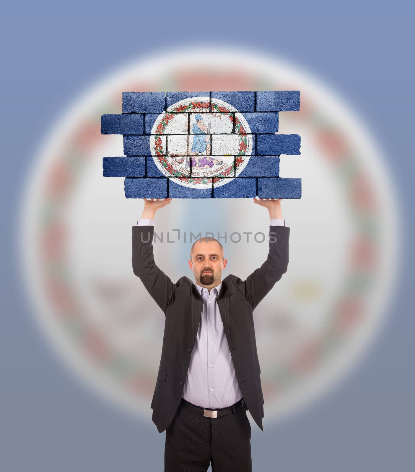 Businessman holding a large piece of a brick wall, flag of Virginia, isolated on national flag