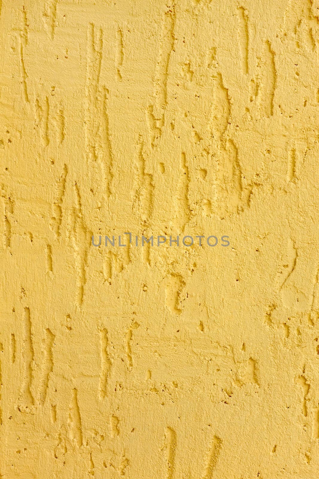 Fragment of a relief plaster walls yellow color closeup as a texture