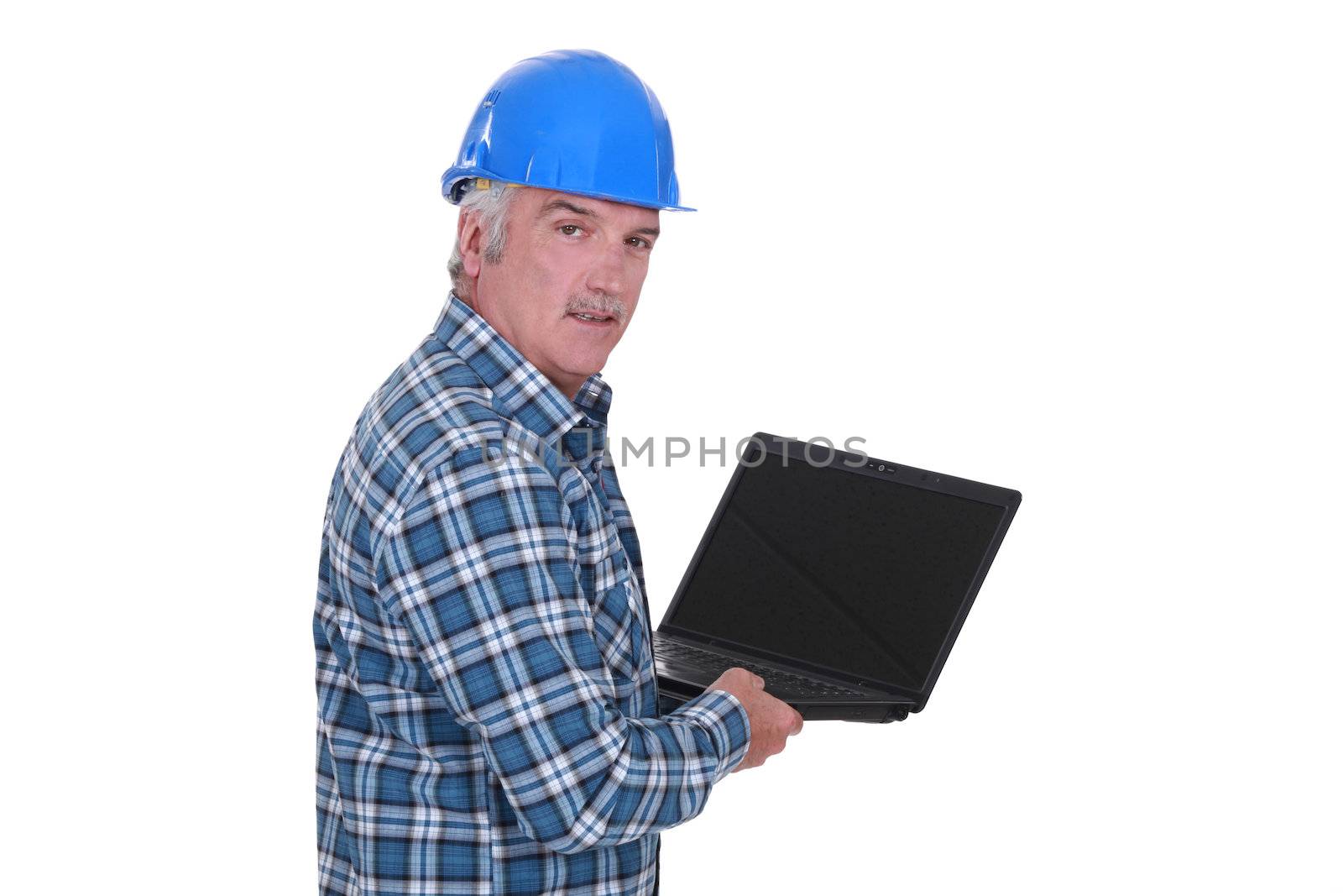 senior craftsman holding a laptop by phovoir