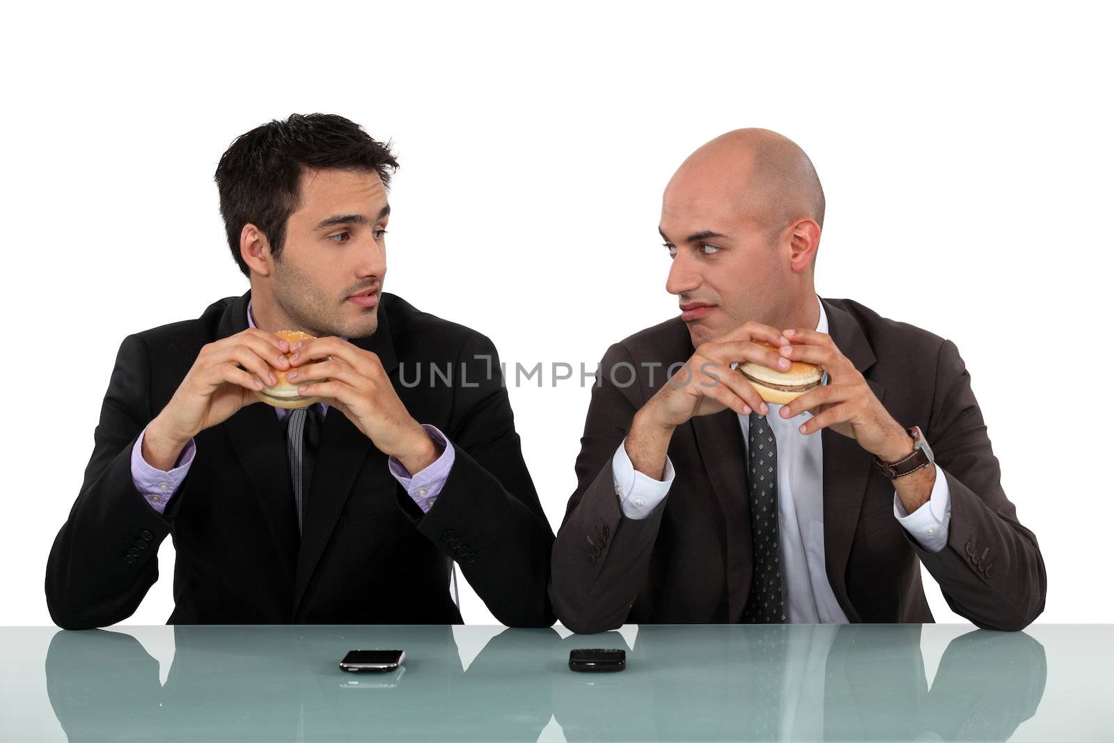 duo of businessmen eating hamburger by phovoir