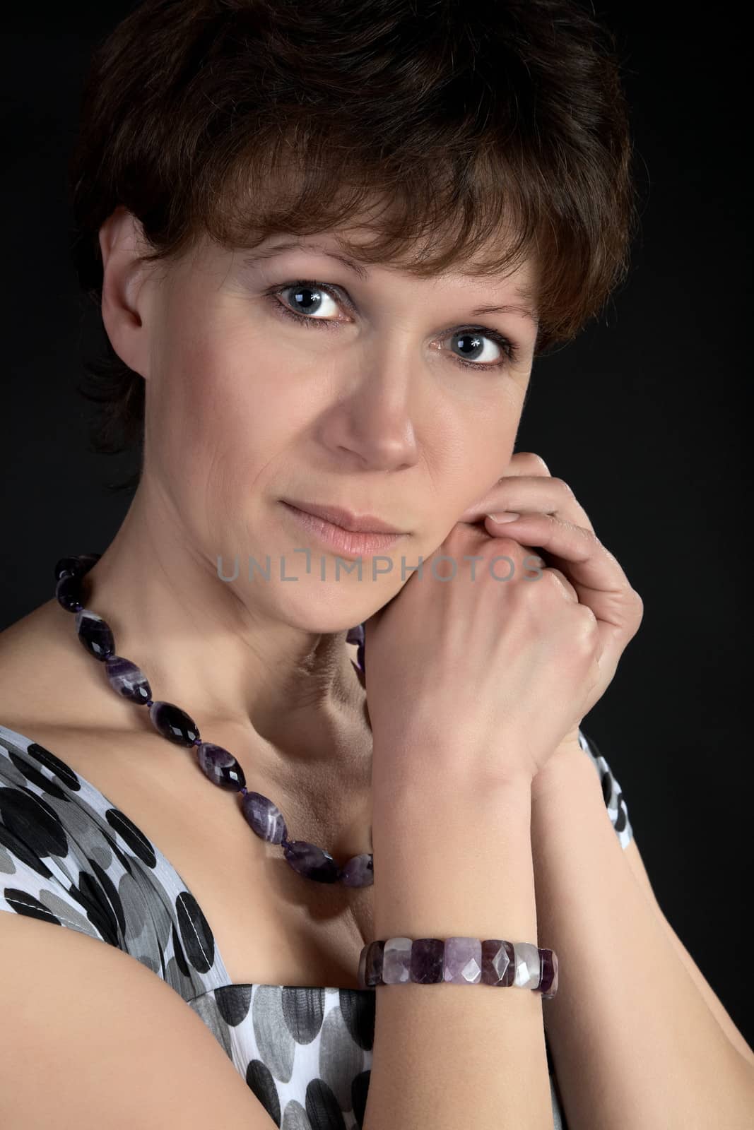 The woman of middle age with  beads on a black background