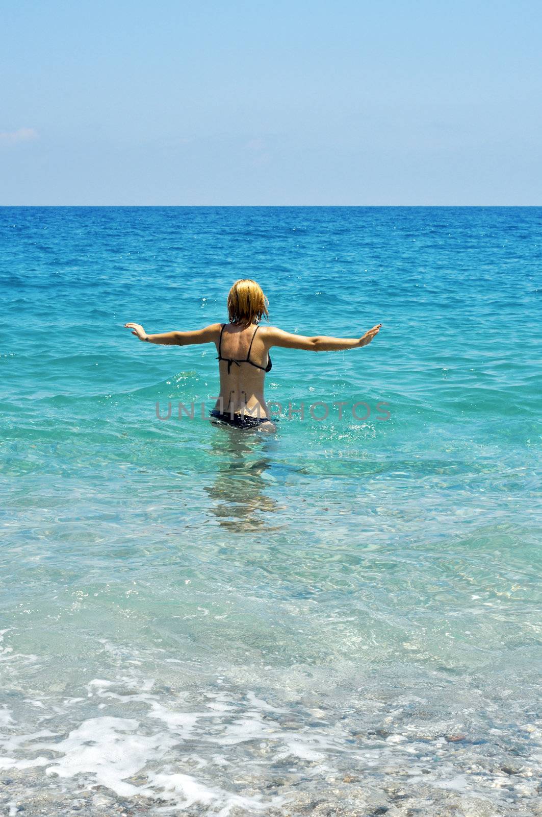 young blonde woman into the mediterranean sea water