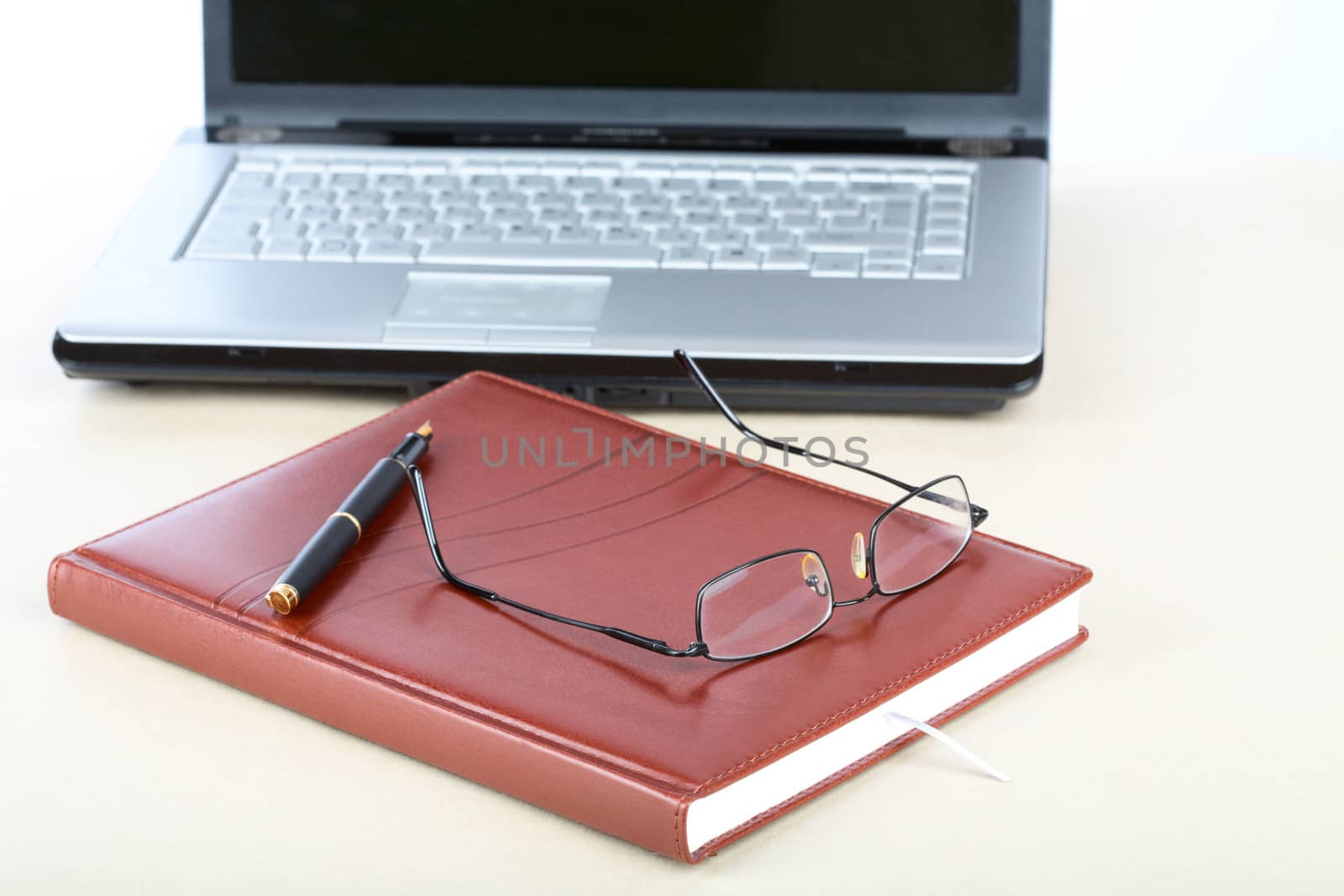 Organizer, glasses,pen and notebook on a desk