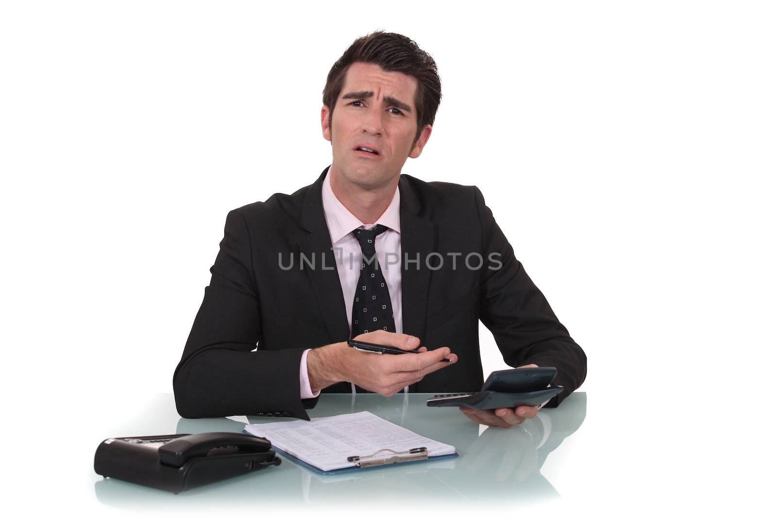 Confused businessman with a calculator by phovoir
