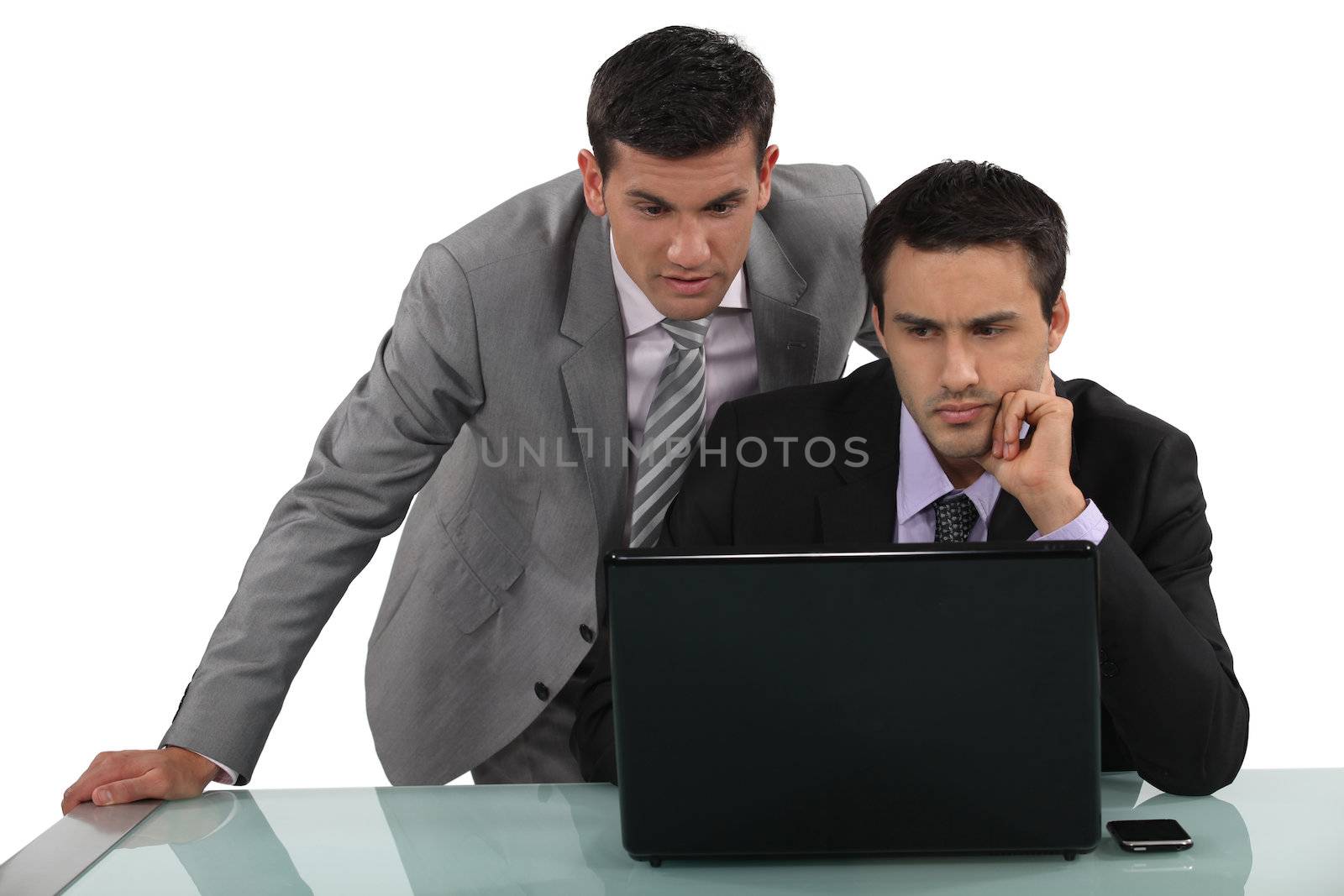 Business associates reading a distressing e-mail by phovoir