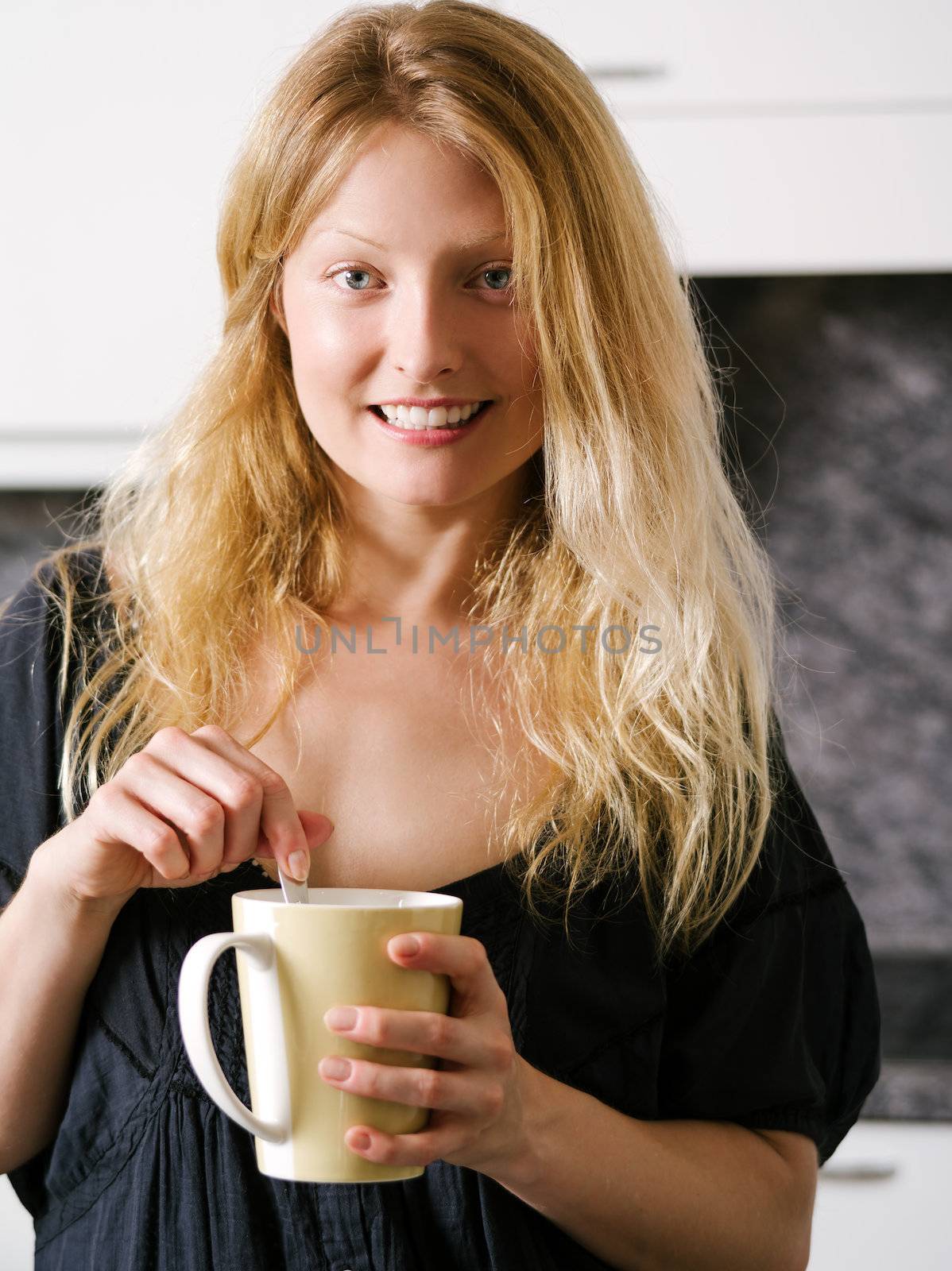 Blond female enjoying coffee at home by sumners