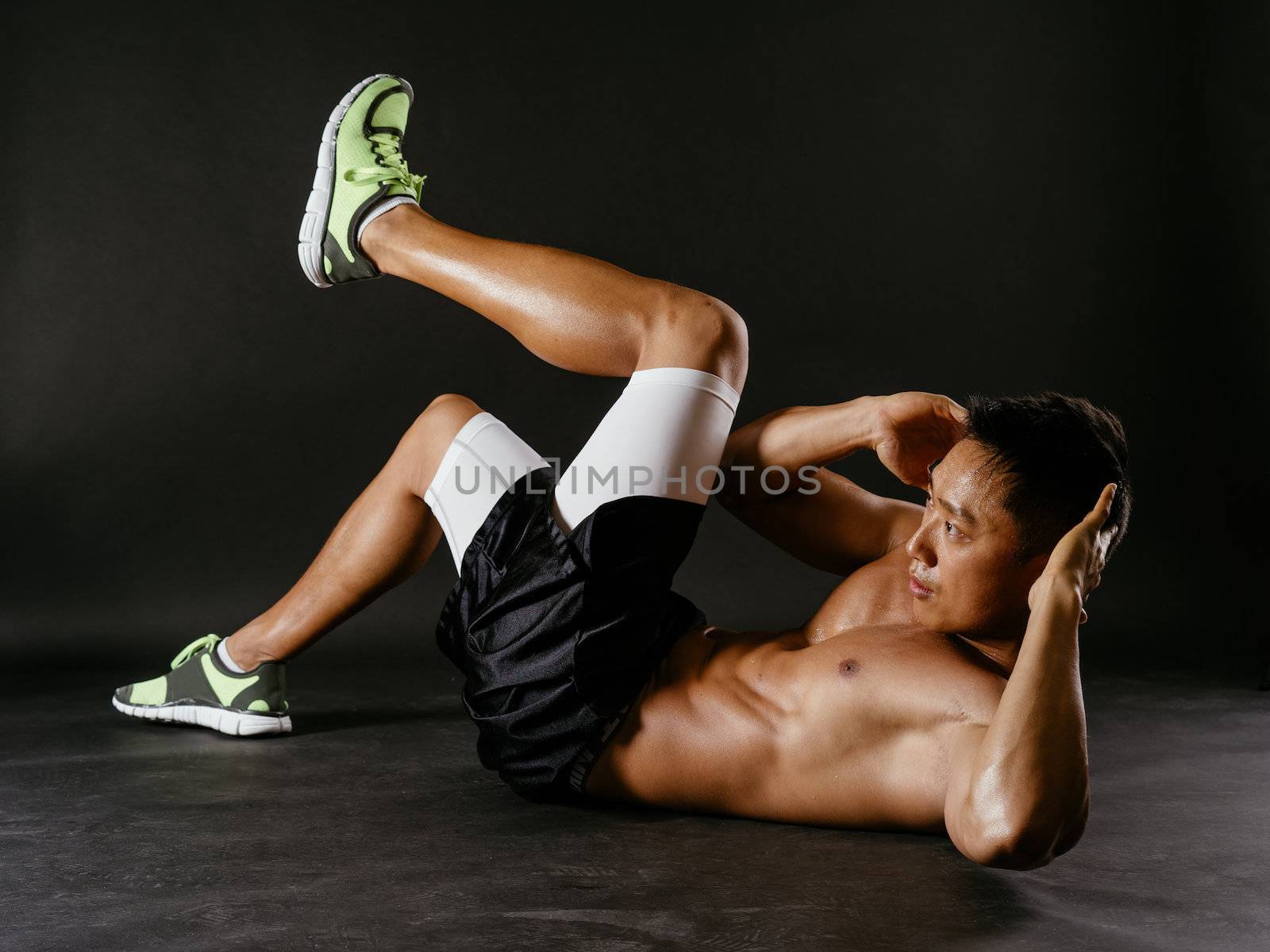 Asian man exercising his stomach muscles by sumners