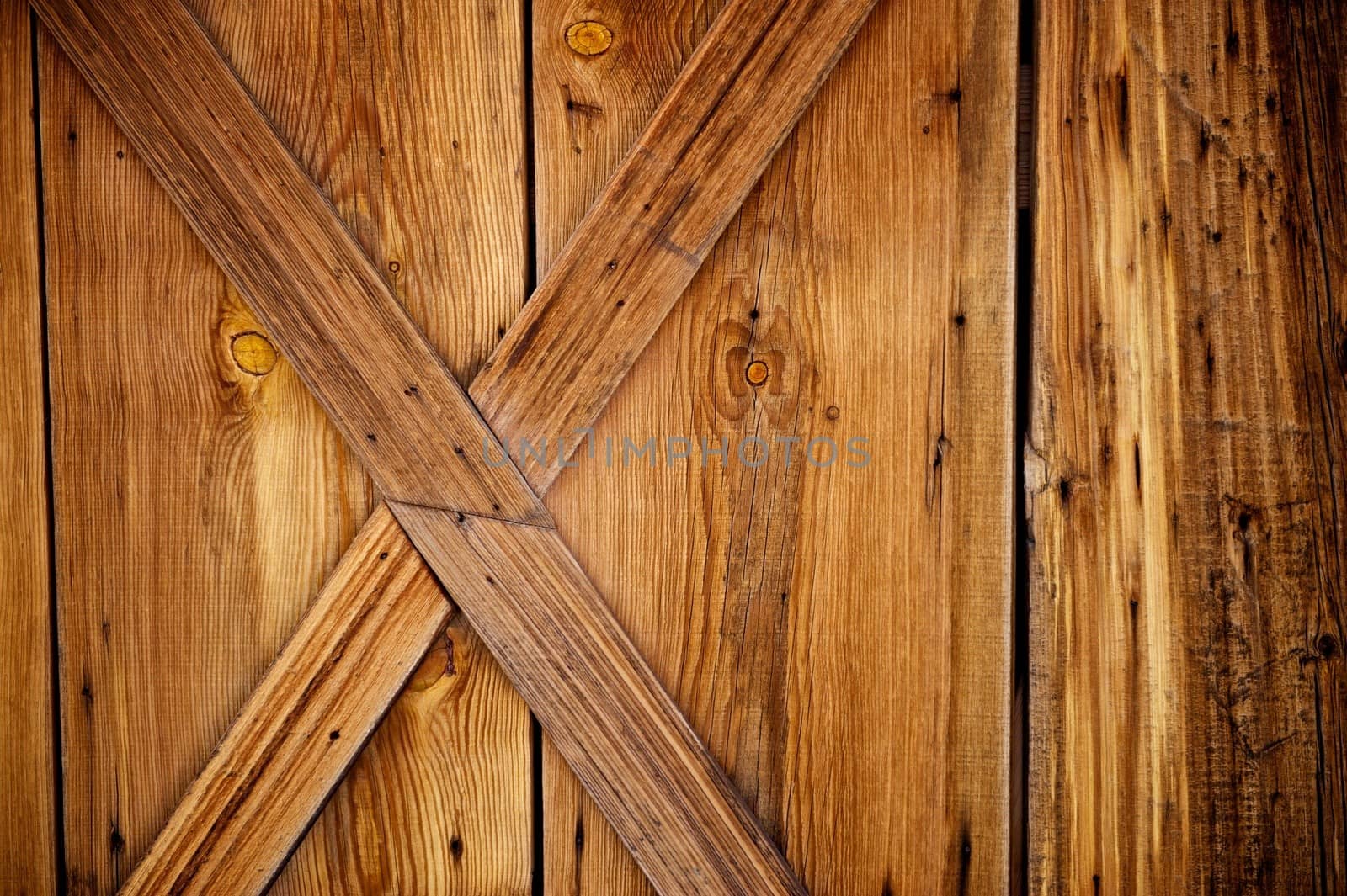 Barn door details with weathered and worn wood planks that include rusty nails and knots
