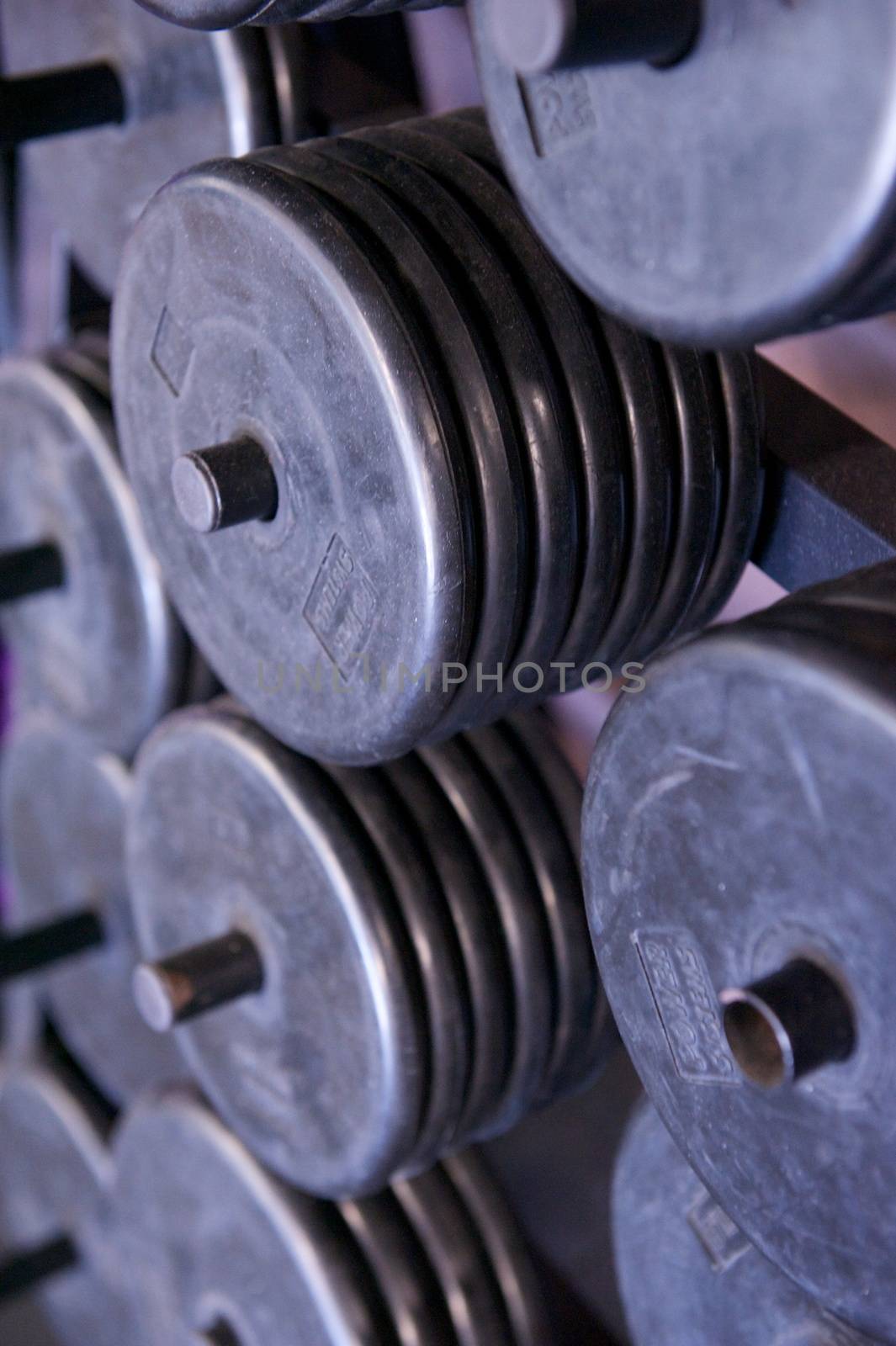 Rack of Free Weight Plates at a Professional Gym by pixelsnap
