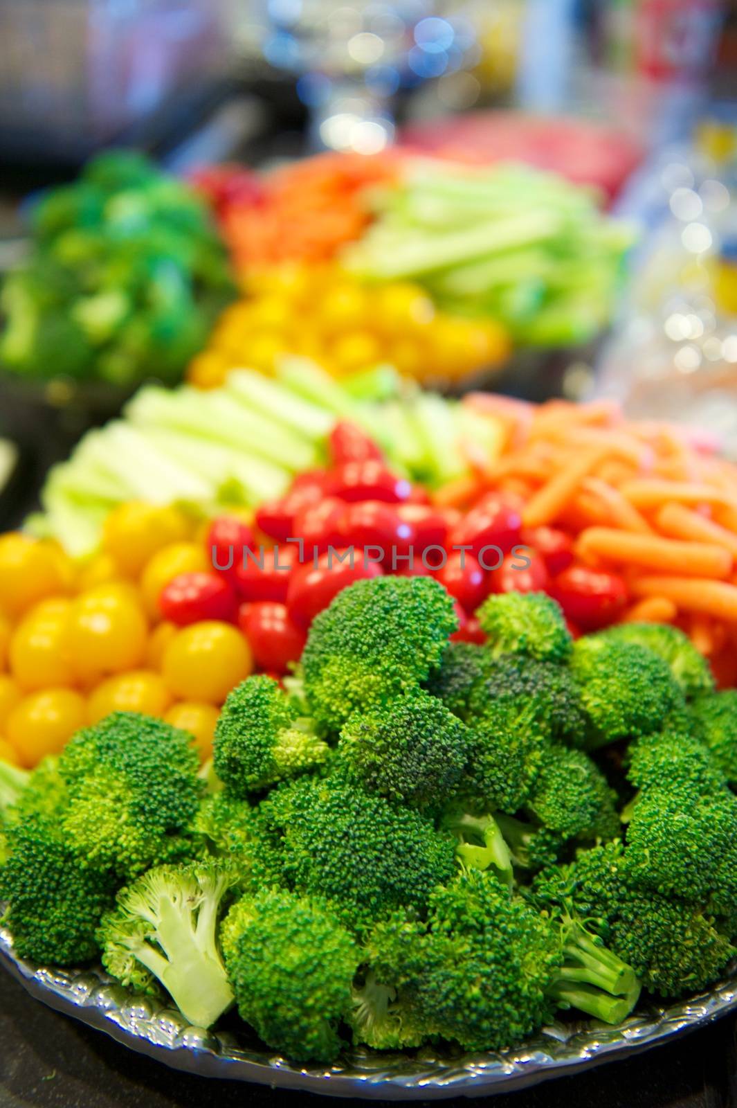 Bright and colorful spread of fresh vegetables on a shiny silver platter in vertical format