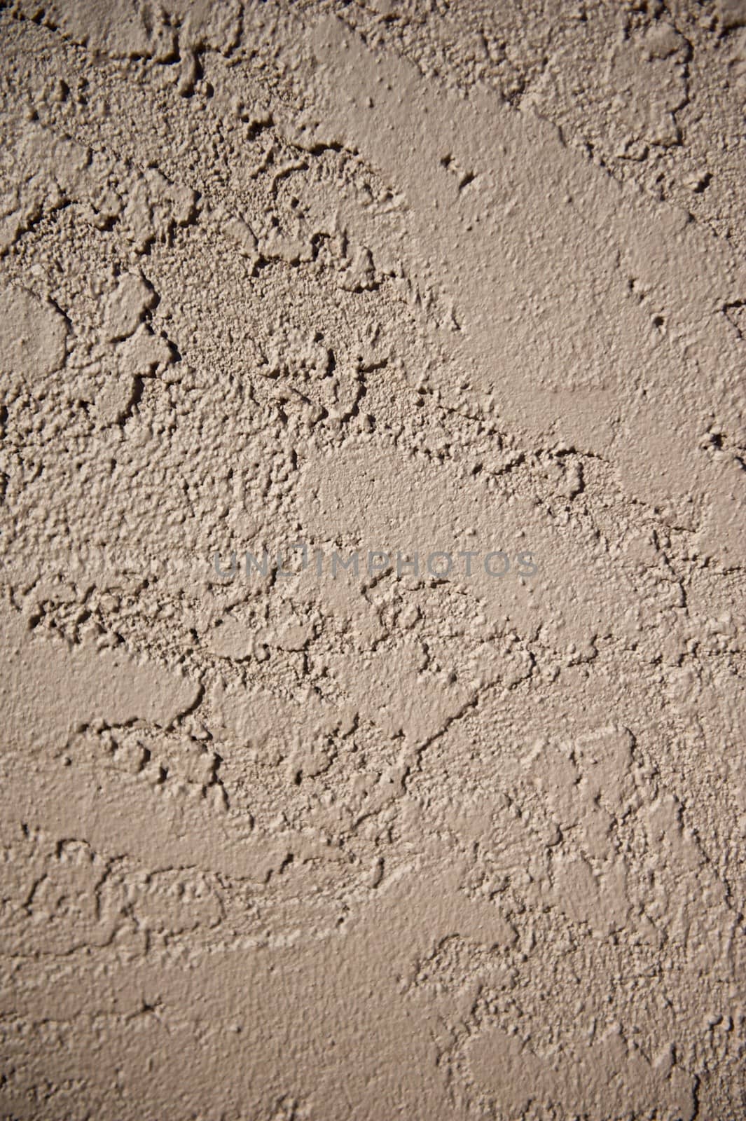 Wall of a home constructed with a brown stucco exterior finish