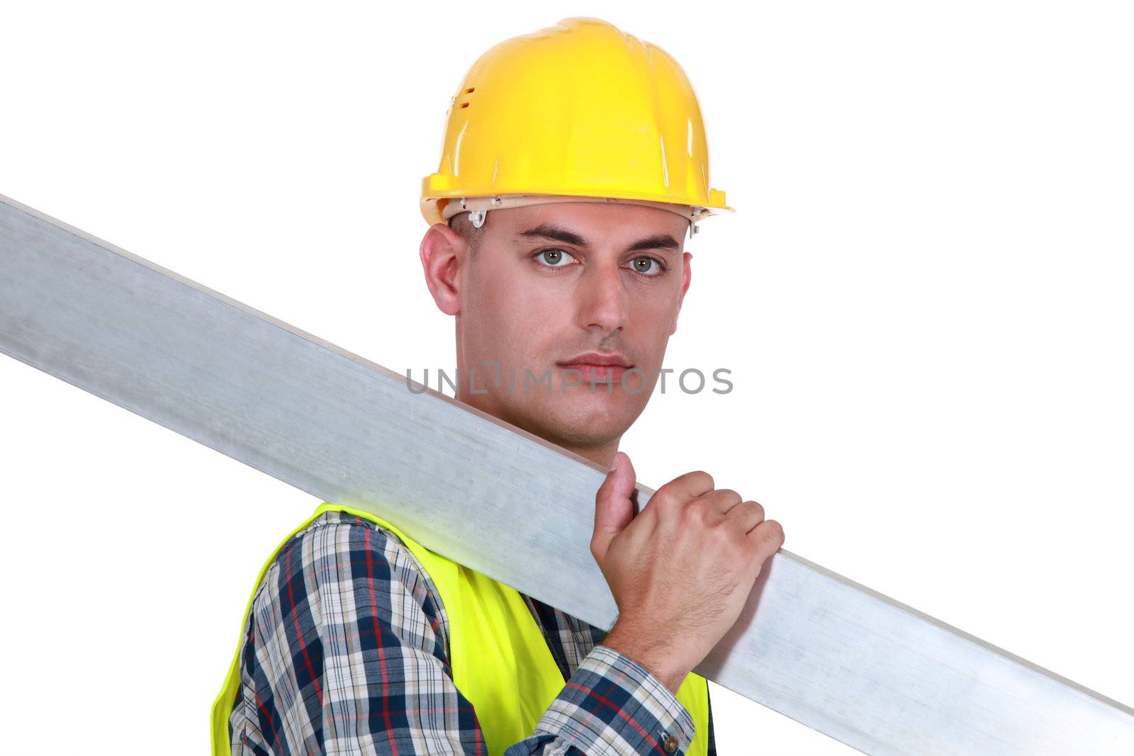A construction worker carrying a steel plank.
