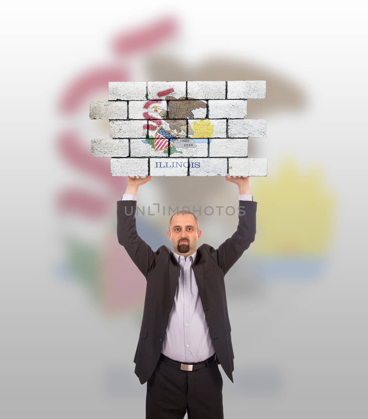 Businessman holding a large piece of a brick wall by michaklootwijk