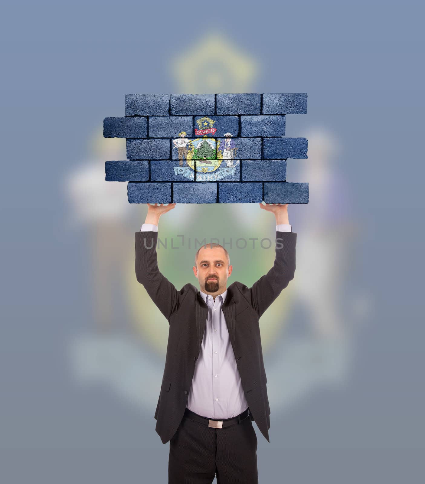 Businessman holding a large piece of a brick wall, flag of Maine, isolated on national flag